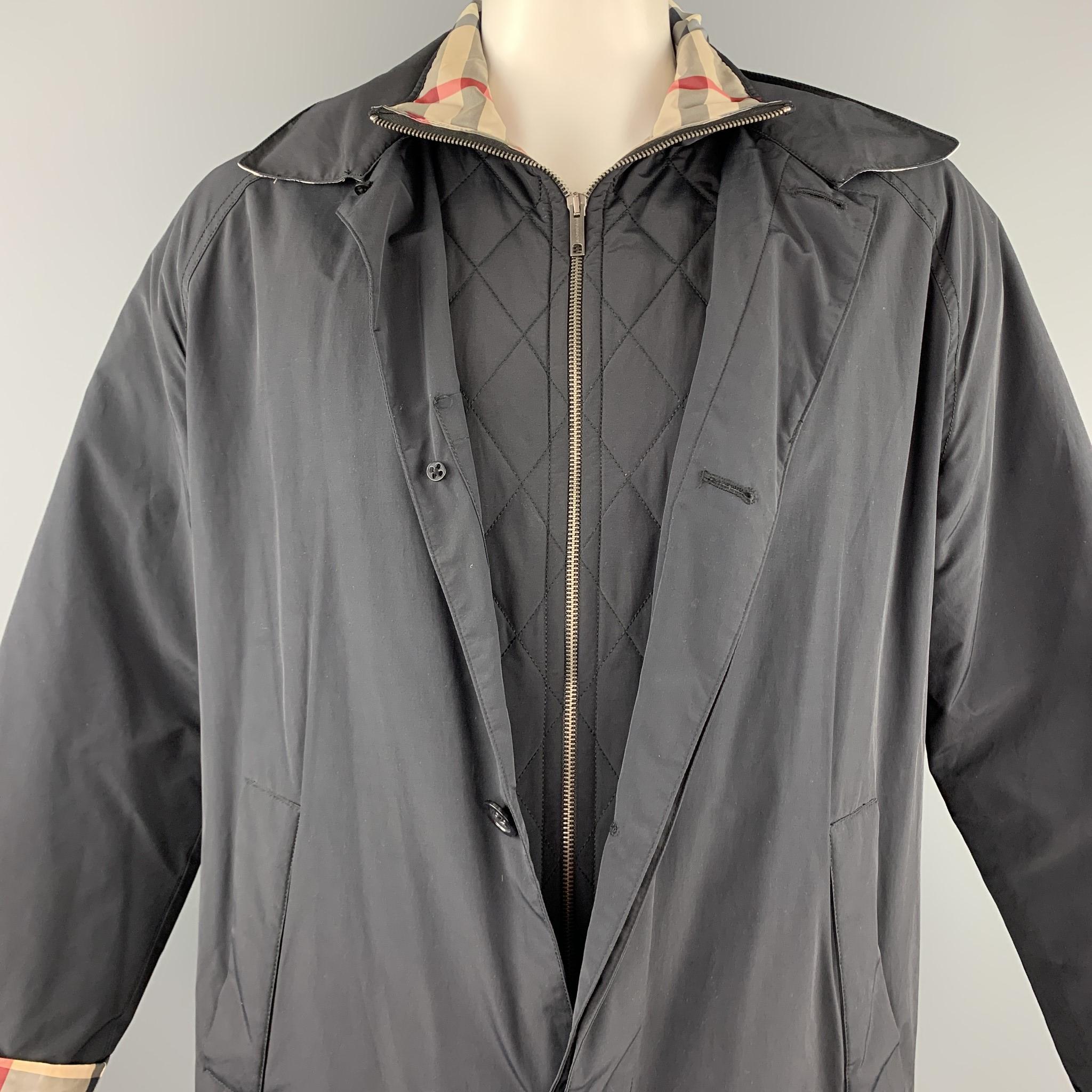 BURBERRY LONDON coat comes in a navy nylon / cotton featuring slit pockets, back vent, signature plaid trim, detachable jacket, and a hidden button closure. Discoloration throughout. As-is.

Good Pre-Owned Condition.
Marked: