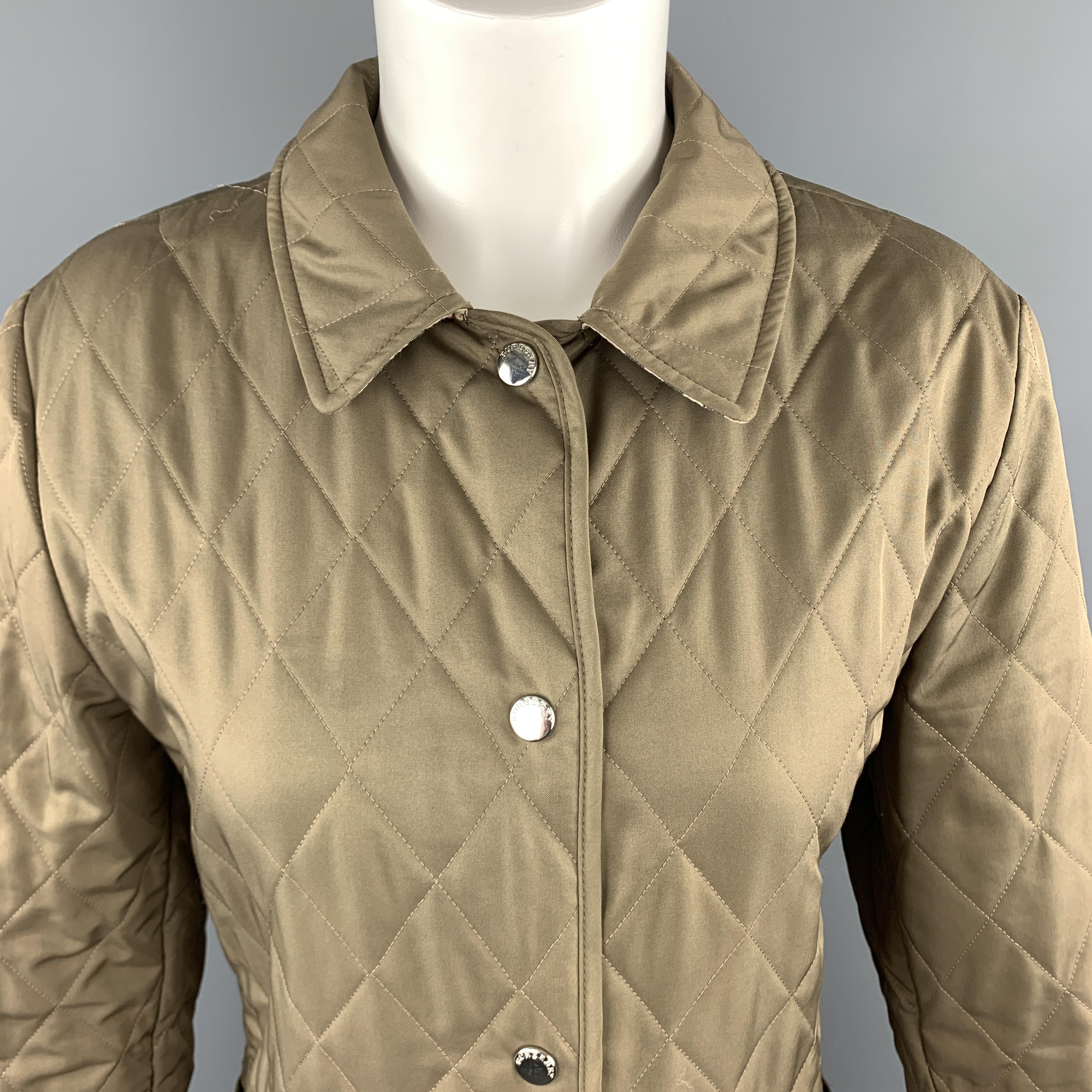 BURBERRY jacket comes in olive green quilted twill with a silver tone snap up closure, patch pockets, pointed collar, and plaid liner. Minor wear.  Made in England.

Very Good Pre-Owned Condition.
Marked: (no size)

Measurements:

Shoulder: 16