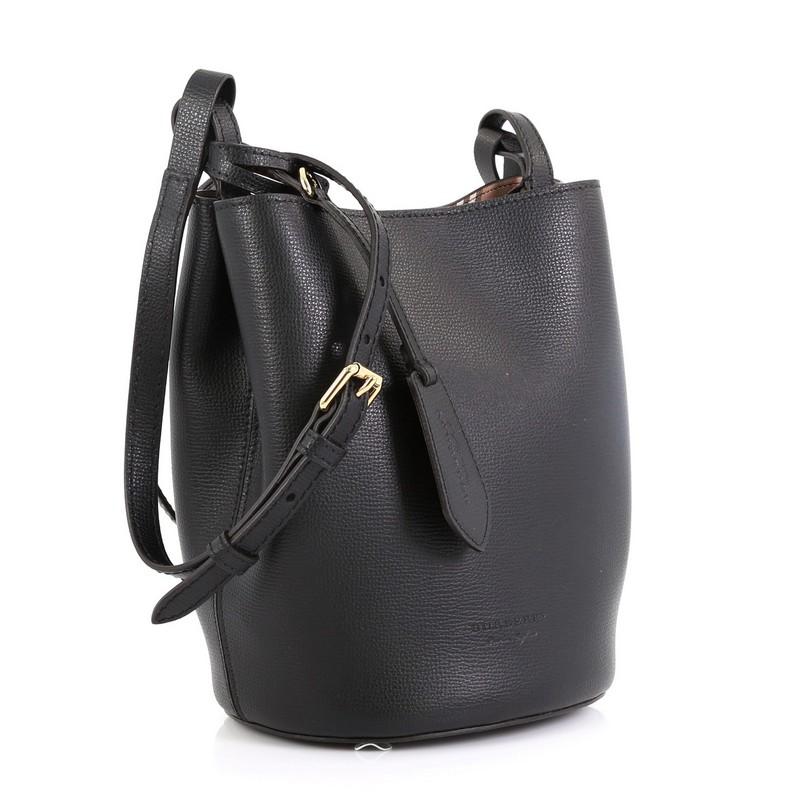 This Burberry Lorne Bucket Bag Leather Small, crafted from black leather, features adjustable flat shoulder strap and gold-tone hardware. Its hidden magnetic closure opens to a brown printed leather interior. 

Estimated Retail Price: