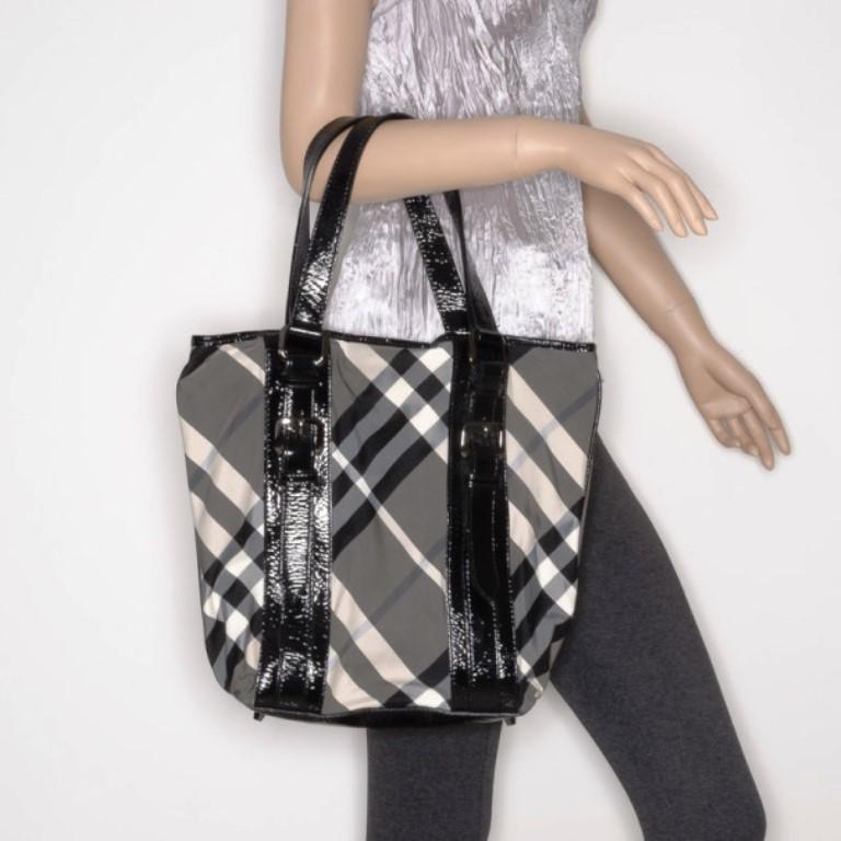 This classic Burberry check tote, with matching wallet, will get you through all your daily errands, looking chic and sophisticated. The exterior of the tote is crafted from Burberry's iconic check pattern canvas with patent leather trim that
