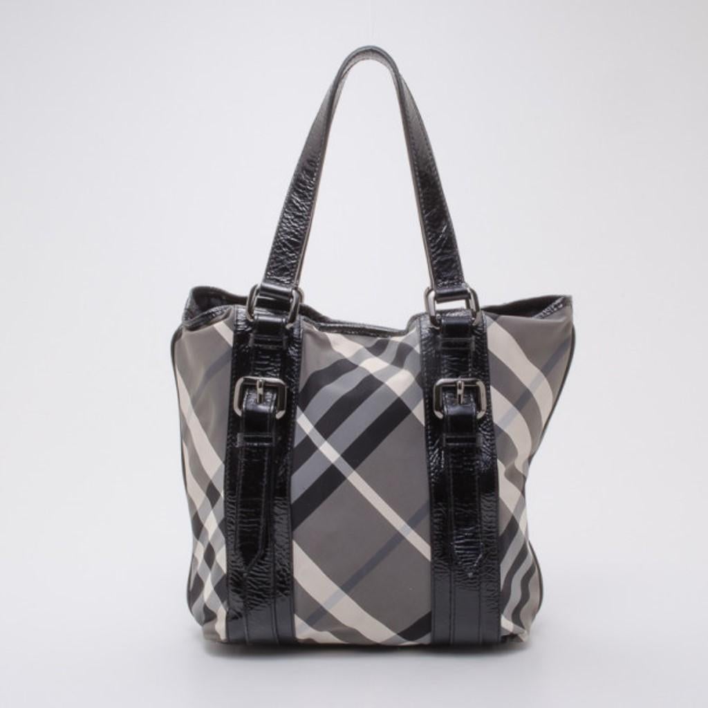 This classic Burberry check tote, with matching wallet, will get you through all your daily errands, looking chic and sophisticated. The exterior of the tote is crafted from Burberry's iconic check pattern canvas with patent leather trim that