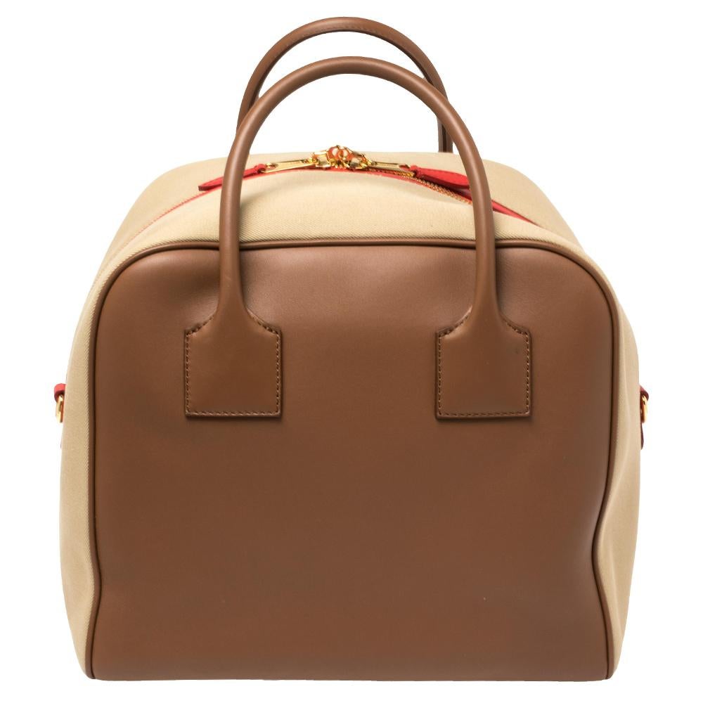 This finely-crafted Bowling bag by Burberry has been designed to assist you with ease and style on all days. Fashioned using leather and canvas, the bag has two handles, a shoulder strap, padlock-key, and a spacious interior.

Includes: Original