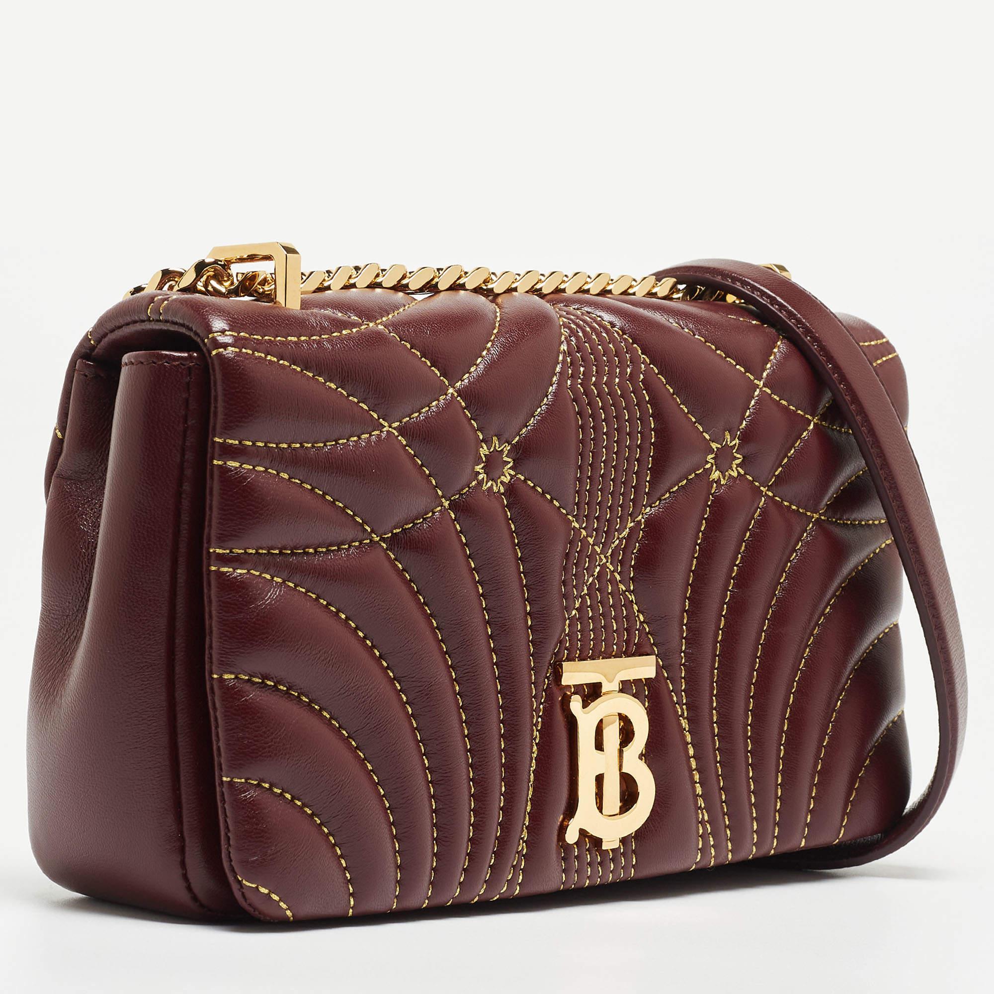 This Lola shoulder bag from Burberry does complete justice to the brand's heritage and aesthetic. It is made using quilted leather with a gold-toned accent decorating the front. It features a chain shoulder strap and an interior lined with canvas