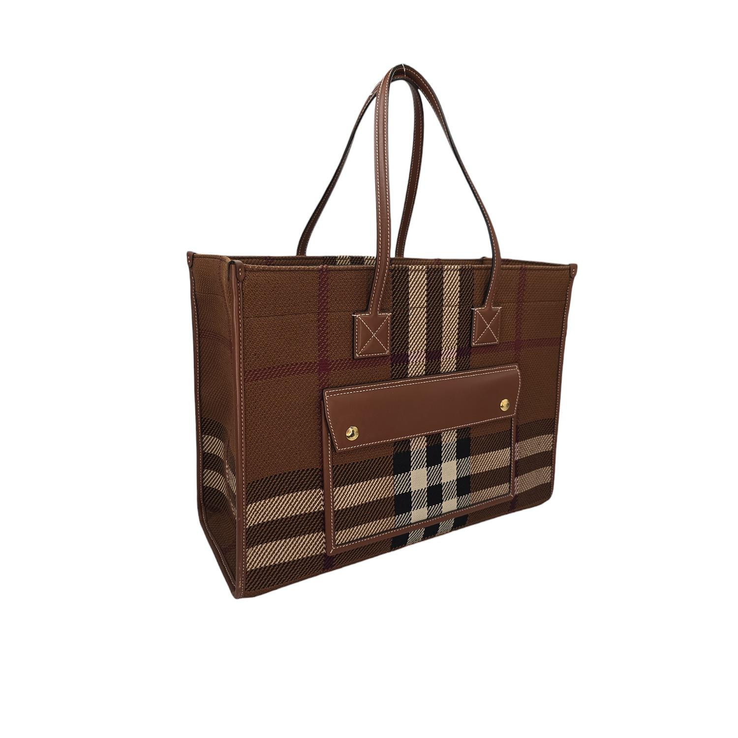 Le fourre-tout Freya en toile à carreaux de taille moyenne de Burberry est un luxueux mélange de toile et de cuir de veau lisse d'un brun riche. Parfait pour un usage quotidien, il est doté d'une poche à rabat sur le devant, de poignées en cuir et