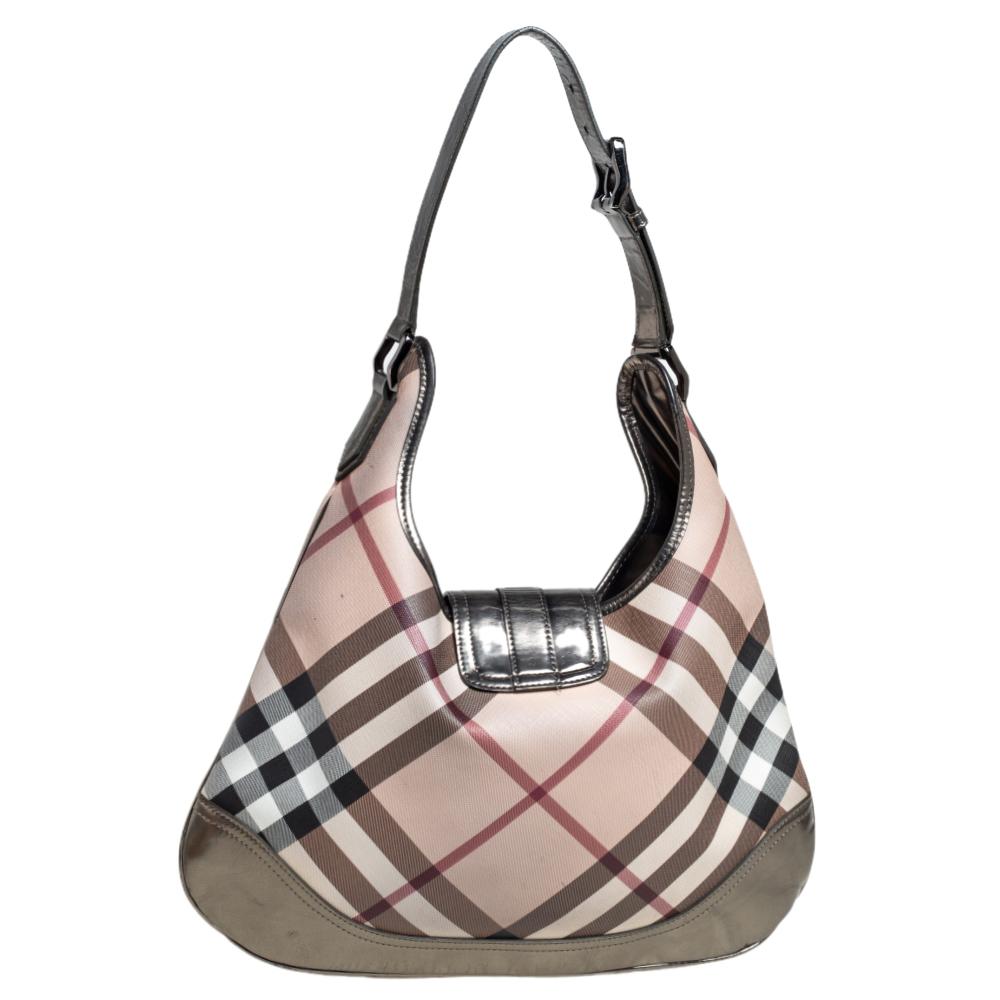 Catch admiring glances when you swing this Brooke hobo by Burberry. It is crafted from Nova-checked PVC and metallic leather. The flap closure opens to a spacious canvas-lined interior that is capable of holding all your essentials. The hobo is held