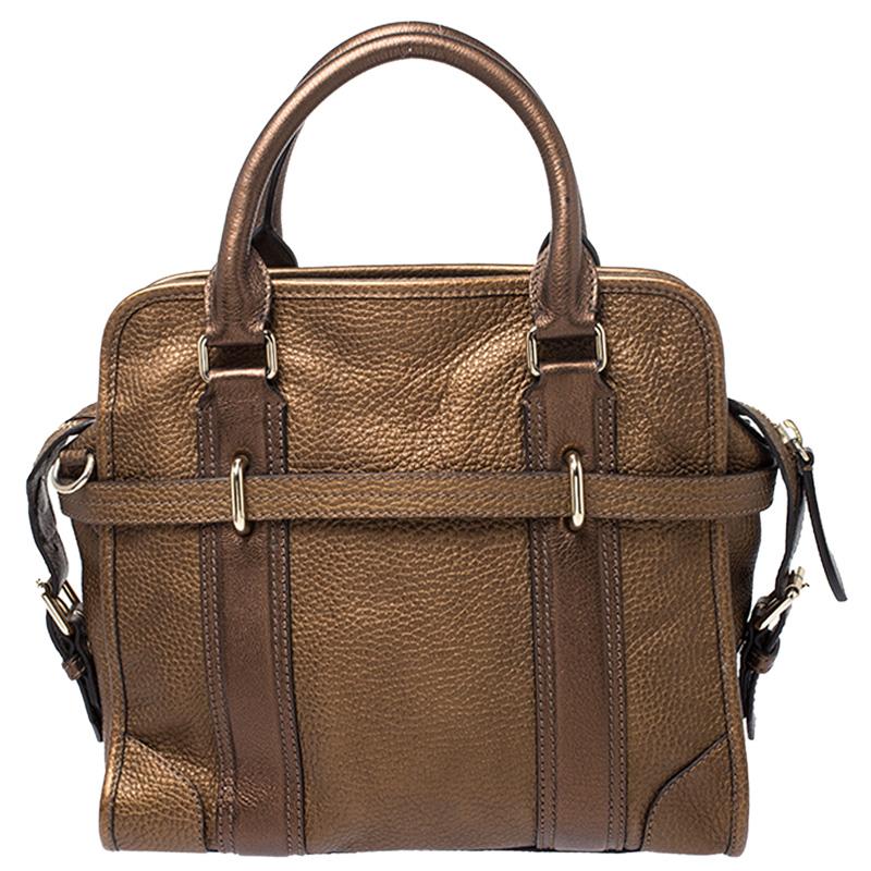 htThis stunning bag by Burberry is classy and sophisticated. It is crafted from quality leather and comes in a metallic brown color. It is held by top handles, a shoulder strap and features a zip closure that leads to a fabric-lined interior with