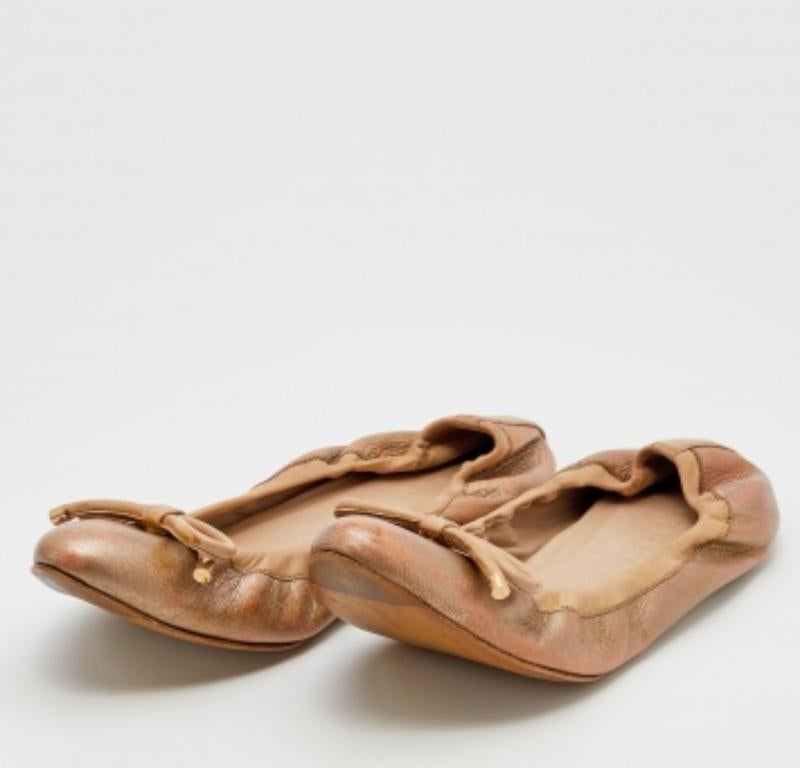 La silueta estriada de estas bailarinas Burberry delineará a la moda tus pies. Confeccionadas en piel dorada metalizada, presentan un lazo en la parte delantera y herrajes dorados. Las suelas duraderas y el ajuste sin cordones dan al par un acabado