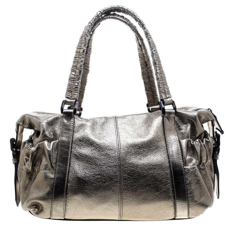 This edgy and stylish Curzon shoulder bag from Burberry is defined by the striking metallic silver leather exterior that adds drama to this glamorous piece. It features drawstring detailing on the exterior body. Carry your day to night essentials in