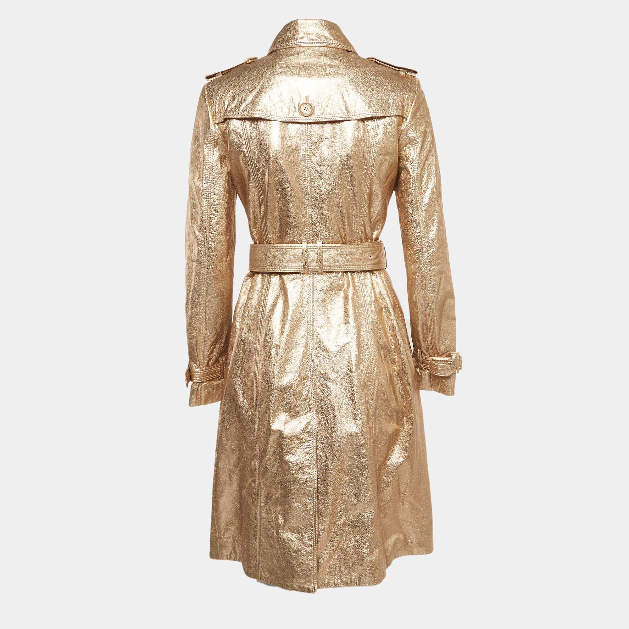 Der Mantel von Burberry ist ein luxuriöses und stilvolles Kleidungsstück. Sie ist aus hochwertigem goldfarbenem Leder gefertigt und verfügt über einen Zweireiher für einen klassischen Look. Der Mantel strahlt mit seiner maßgeschneiderten Passform,