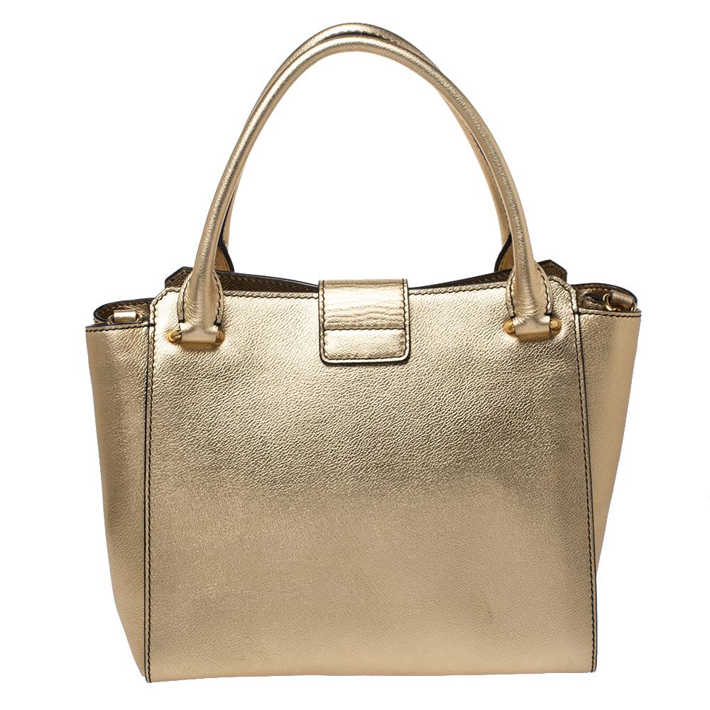 Featuring two handles, and a large buckle flap, this Burberry tote is the kind of bag you would want to swing every day. The metallic gold leather bag features a spacious fabric compartment to house all your essentials and dual handles & a check