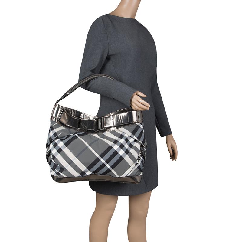 Fashioned in the label's signature Check pattern, this Burberry bag features a grey body and detailed with leather trims. It comes with a metallic grey top and rolled top handle. This chic yet practical bag is ideally proportioned to hold all your