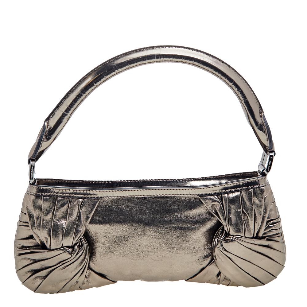 Look extra chic and elegant with this Burberry metallic bag that's perfect for evening events. It features pleated side knots in the front and back, a top zip closure, and a black-tone placard in the front with the Burberry logo on it. The interior