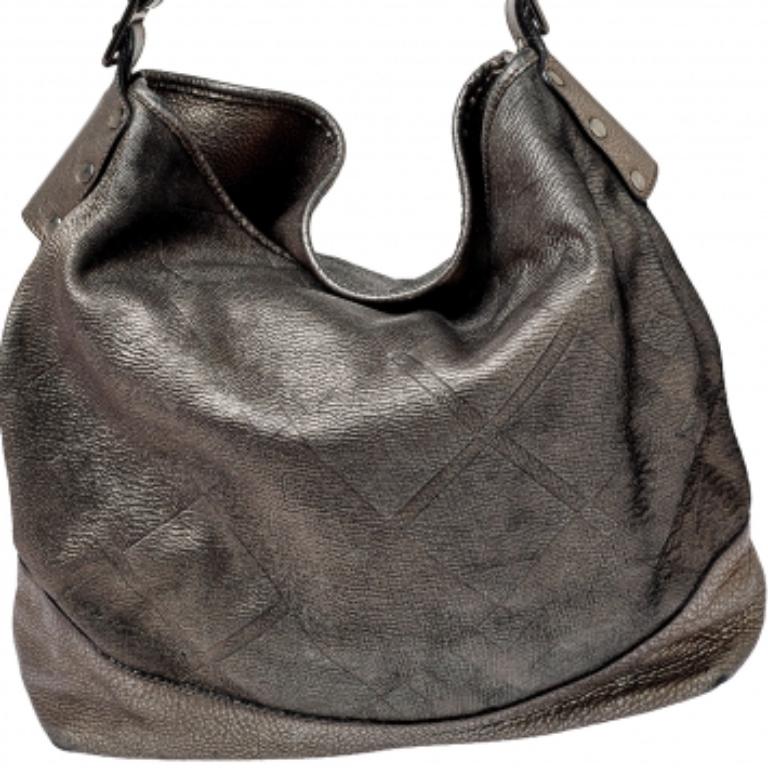 This hobo by Burberry combines function and fashion. Crafted from leather, the bag features a spacious fabric interior to house your everyday essentials. The hobo flaunts a metallic silver hue and it is held by a single handle.