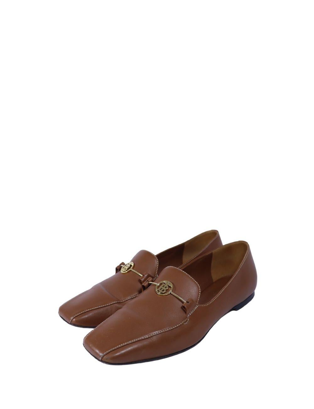 Elevate your smart-casual wardrobe with these Burberry tan leather loafers, crafted from smooth leather and finished with elegant gold-tone Thomas Burberry (TB) monogram hardware. The sleek silhouette and squared toe offer a refined, contemporary
