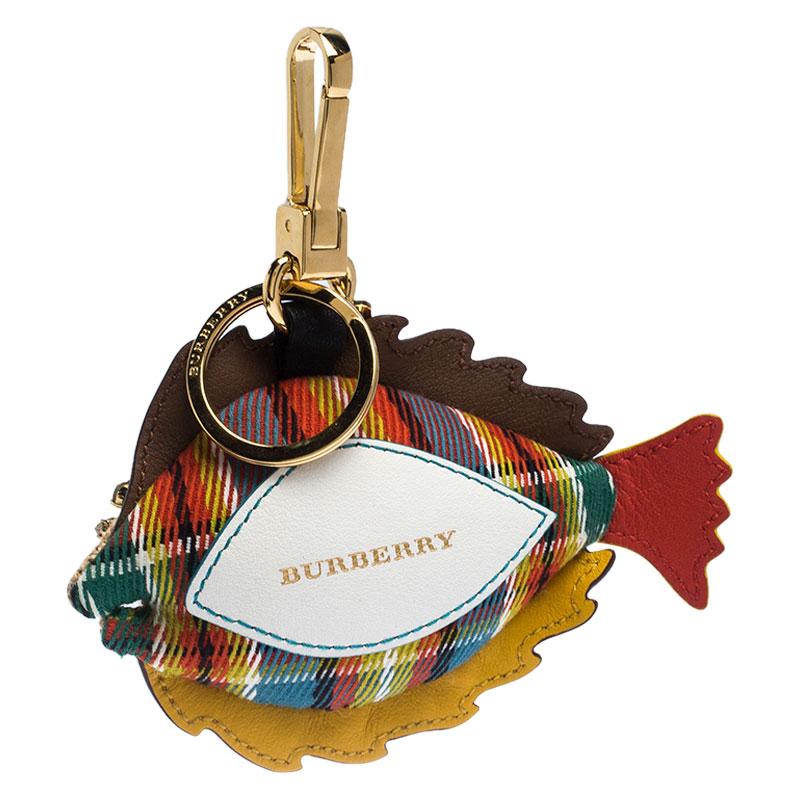 This bag charm from Burberry is crafted from multicoloured leather and jute. It is astoundingly designed in the shape of a fish. It accented with gold-tone and crystal-embellished studs and has a gold-tone lobster clasp along with an engraved