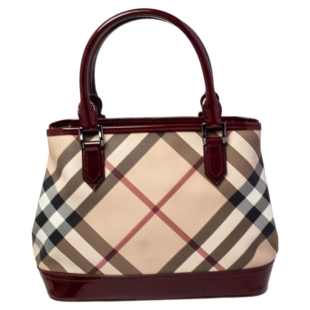 Carry this Burberry tote for a statement-making look. Crafted from PVC and styled with patent leather, this tote flaunts the signature Nova check pattern. It is held by dual handles and comes with a canvas-lined interior.