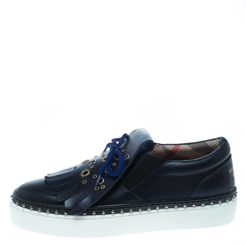 Sleek and super comfortable, this pair of sneakers by Burberry will make a fantastic addition to your shoe collection. They've been crafted from navy blue leather and styled with ties and fringe details on the uppers. Studs and platforms beautifully