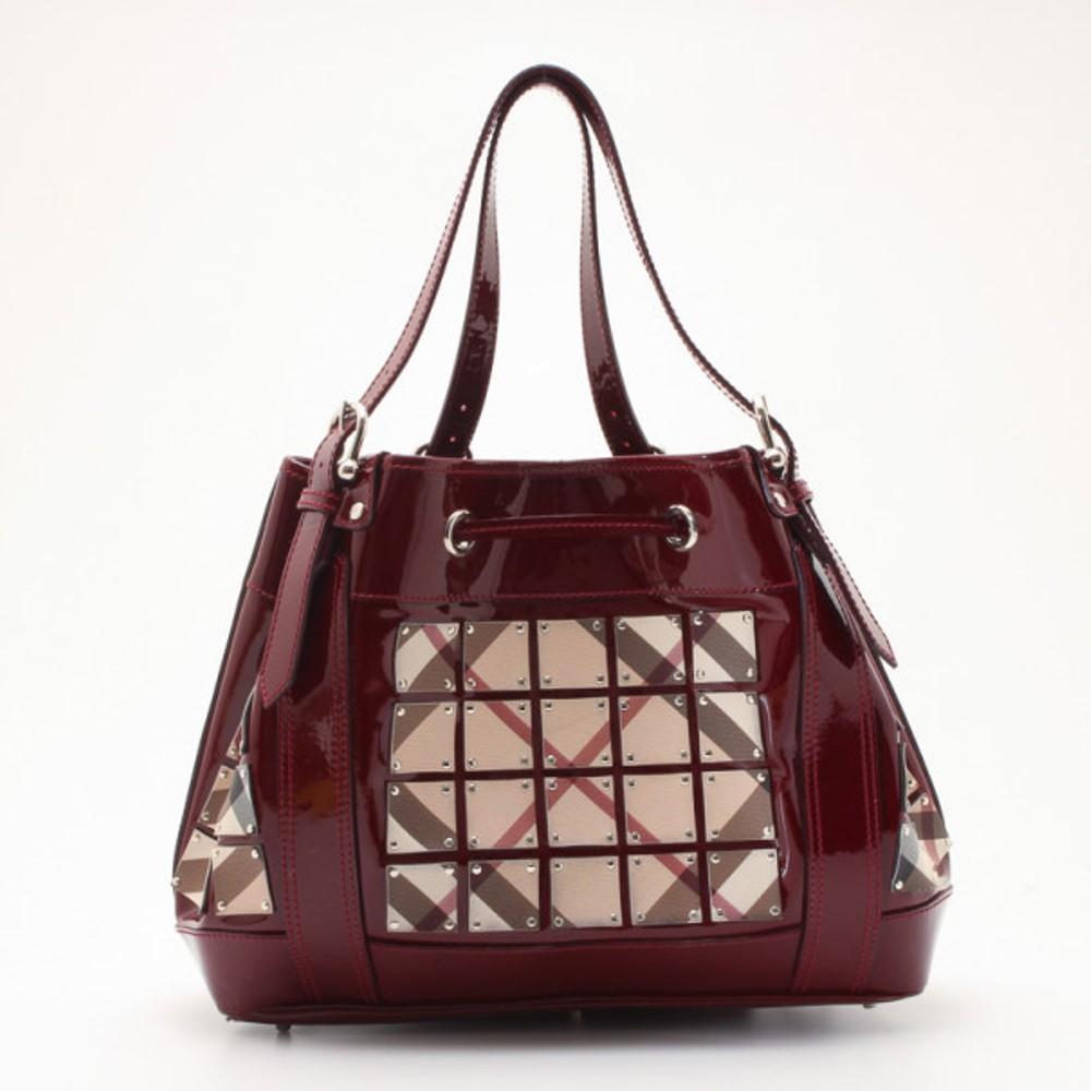 Turn heads with this sublime Burberry Warrior Bag. It is crafted from deep crimson nylon complemented with geometrical patterned fabric, chrome finish and engraved rivets. The slim straps hold the bag with sturdy metal buckles. The interior is lined
