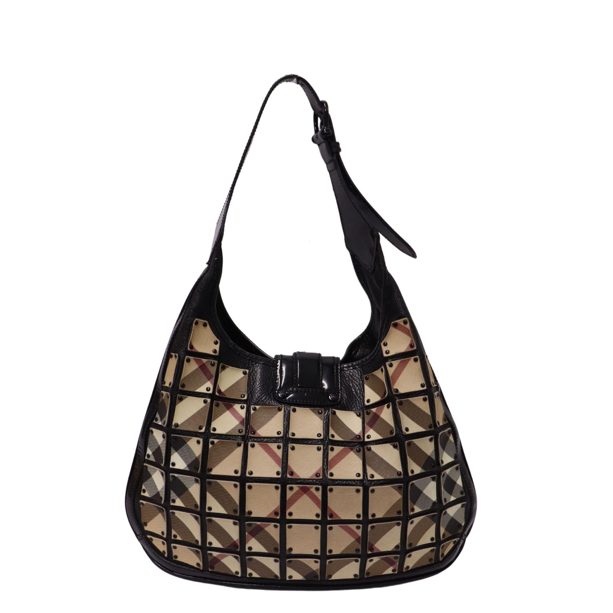 Burberry warrior nova check ‘Brooke’ Hobo. Featuring individual square panels of their iconic check print in canvas and black patent leather trim. The exterior features a buckle flap snap closure and a buckle detailed shoulder handle. Interior is