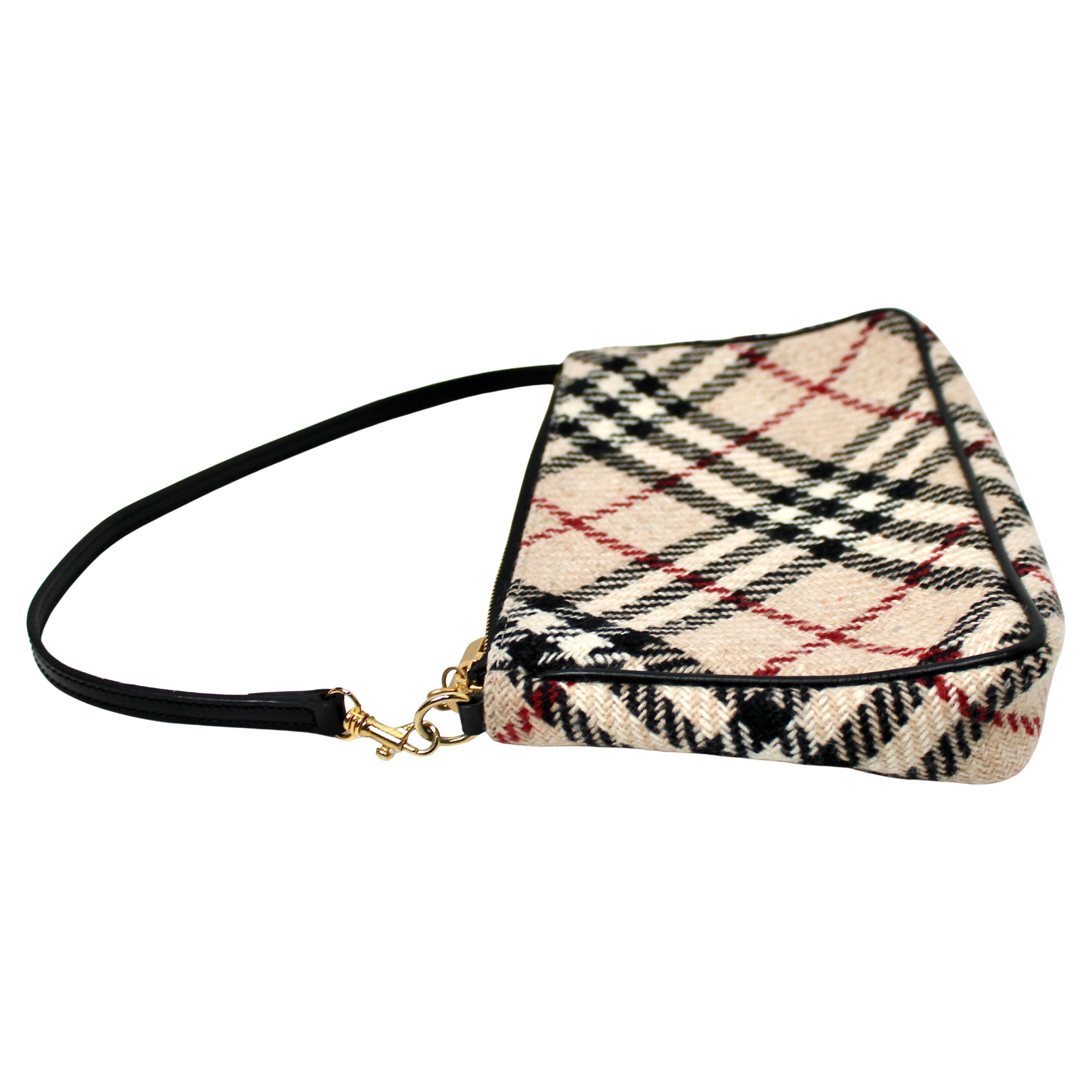 La mini borsa a tracolla Burberry Nova Check Wool del 2000 circa è un accessorio quintessenziale che cattura lo stile distintivo dei primi anni 2000. Realizzata con l'iconico motivo Nova Check di Burberry in un formato compatto e versatile, questa