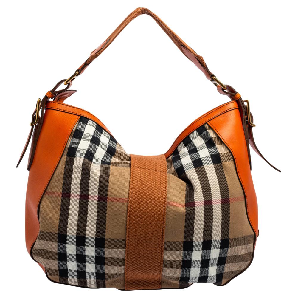 This Burberry hobo bag is an example of the brand's signature designs that are beautifully crafted to lend a classic charm to your look. Made of Nova Check canvas and leather, this hobo bag consists of gold-tone hardware, a detachable strap, a