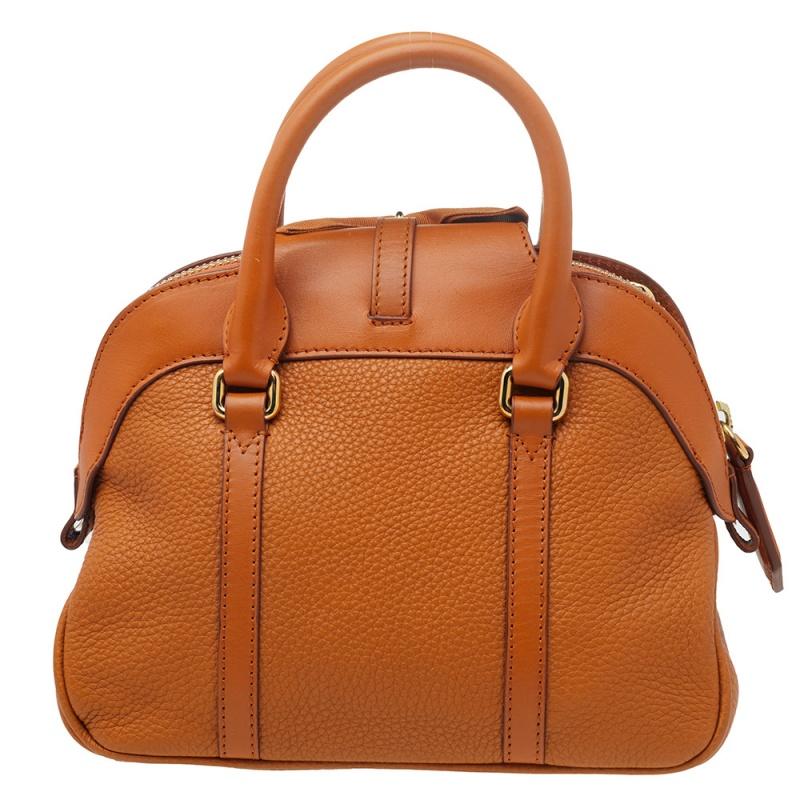 This fashionable bag is luxuriously designed by Burberry. Crafted from leather, it features double top handles, a detachable shoulder strap, a stunning bow on the front, and a top zipper closure. The bag is accented with gold-tone hardware and is
