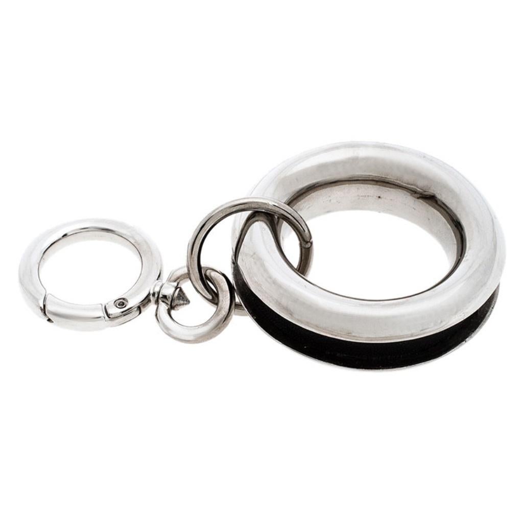 This key charm by Burberry is a creation meant to easily hold your keys. It is crafted from palladium-plated metal and detailed with leather. The grommet charm is fixed to a simple ring clasp.

Includes: Price Tag, Original Box, Info Booklet, The