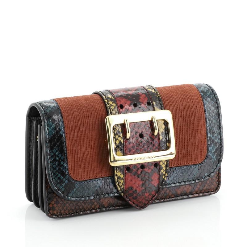 This Burberry Patchwork Buckle Flap Bag Snakeskin with Leather Small, crafted in genuine multicolor snakeskin with orange leather, features an adjustable strap, front flap with buckle and gold-tone hardware. Its magnetic snap button closure opens to
