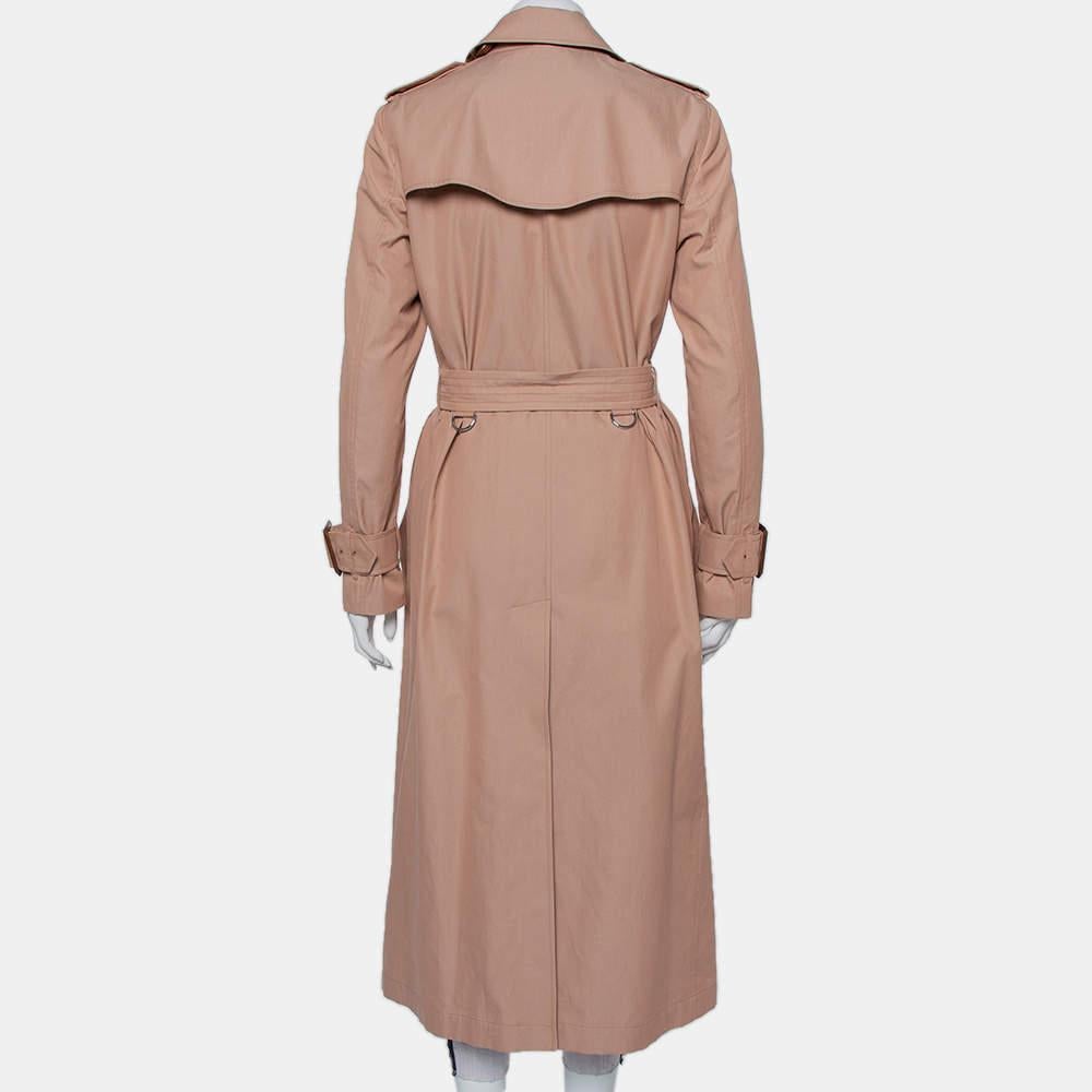 Burberry is known for its trench coats. This creation exudes elegance and is great for casual wear. Crafted from cotton, this pink trench coat is a must-have. It features a double-breasted silhouette with a front button closure, a buckle belt that