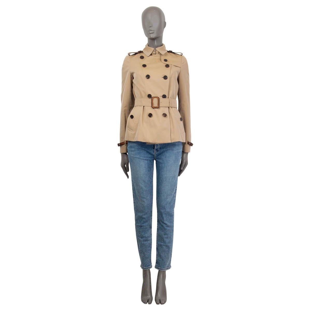 100% authentic Burberry Prorsum belted double breasted trench jacket in beige and tan cotton (100%). Embellished with leather epaulettes at the shoulders and the cuffs. Closes with one hook at the neck, six buttons on the front and a belt at the