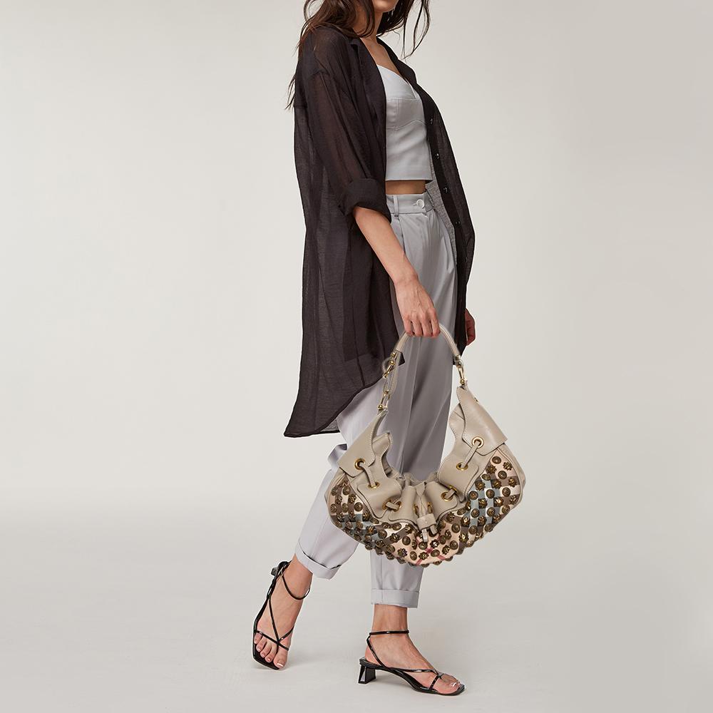 This Burberry Prorsum Warrior hobo will make a splendid addition to your bag collection. It is crafted from durable leather and signature checked canvas and is beautifully designed with gorgeous studs all over the exterior. The bag has a drawstring