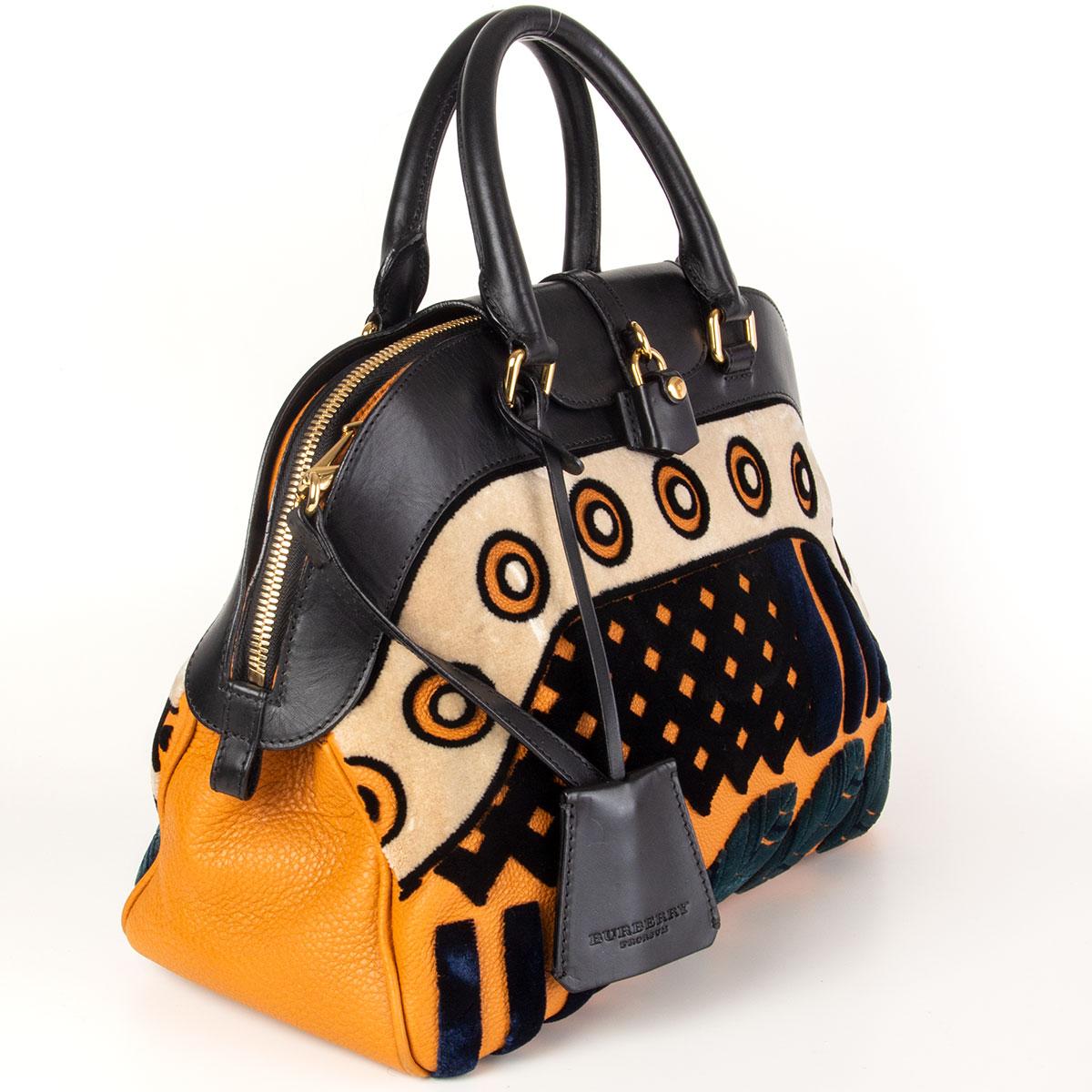 Burberry Prorsum 'Milverton Medium' bowling shoulder bag in black and orange calfskin and midnight blue, black, sand and petrol velvet. Opens with a zipper on top and is lined in black nylon with one zipper pocket against the back and two open