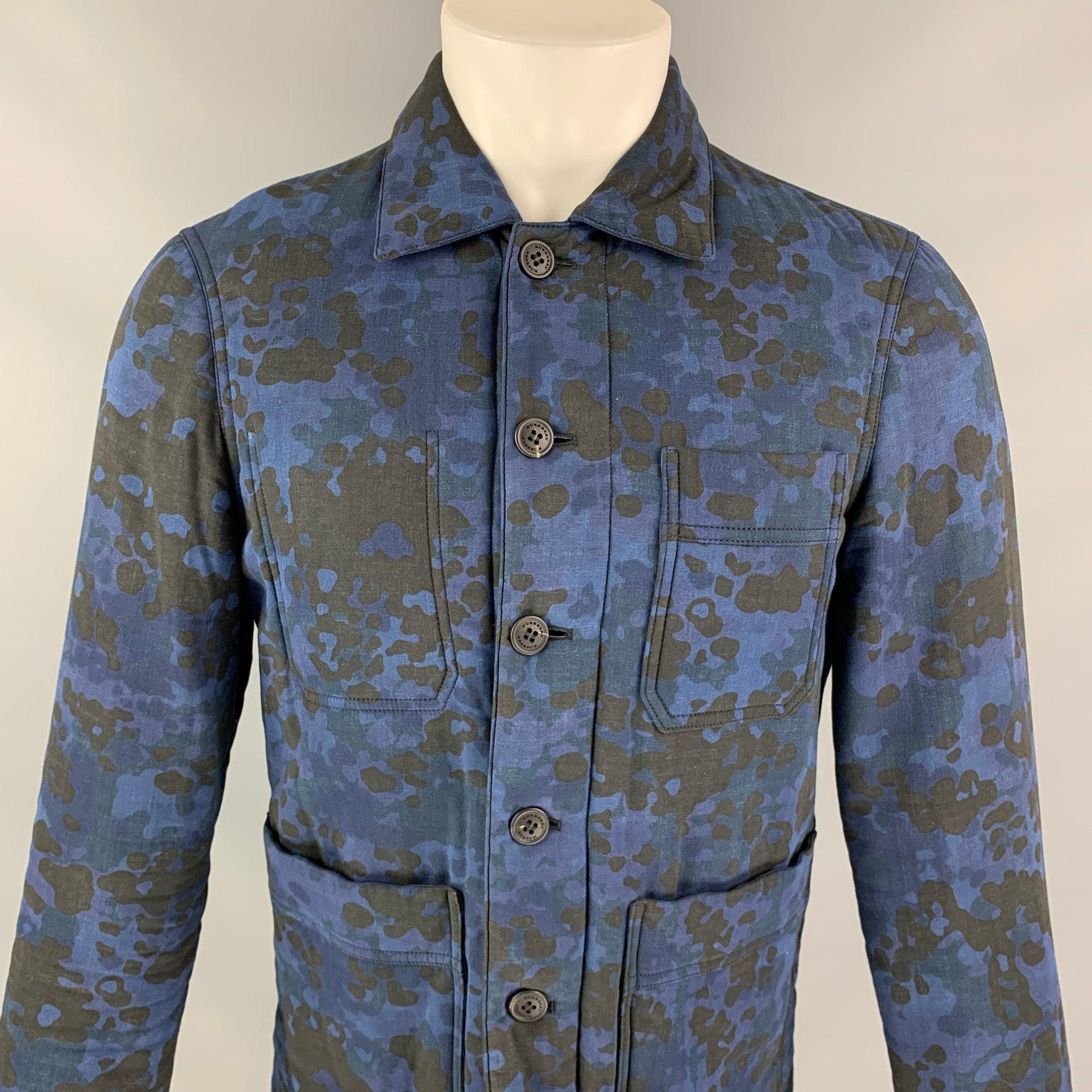 Burberry Camo Floral Print Trucker Jacket featuring a blue tone camouflage print, point collar, patch pickets & button closure.Very Good Pre-Owned Condition. Faint wear, interior brand tag has pen mark. 

Marked:   S  US36, IT46 

Measurements: 
 