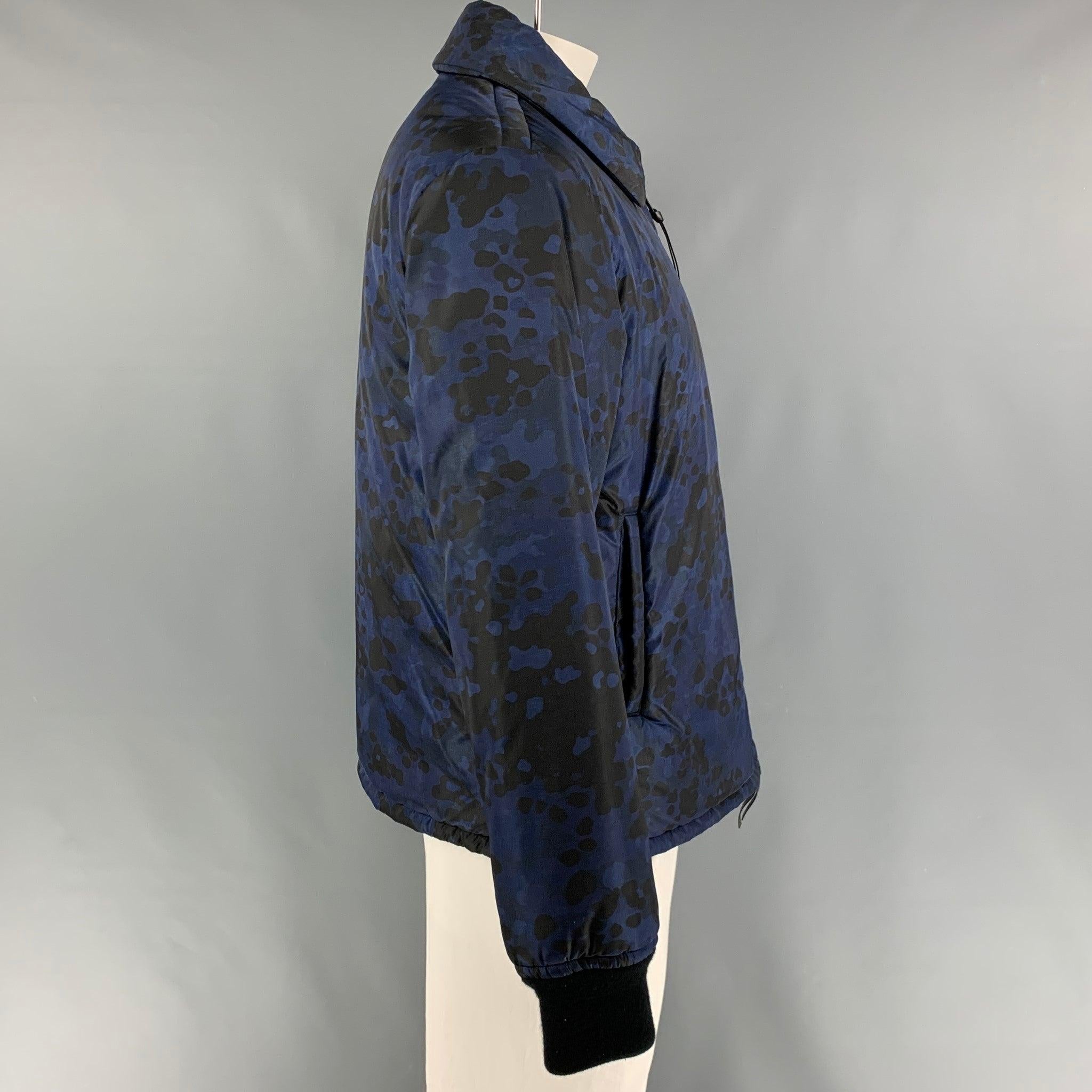 BURBERRY Fall 2015 by Christopher Bailey jacket comes in a navy & blue camouflage polyamide featuring a ribbed hem, slit pockets, spread collar, and a full zip up closure. Made in Italy.
Very Good
Pre-Owned Condition. 

Marked:   52 

Measurements: