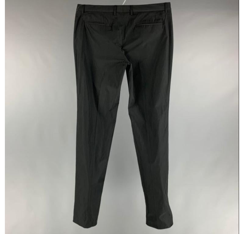Le pantalon habillé PRORSUM de Burberry est réalisé dans une matière tissée en polyester noir et présente un devant plat, des poches passepoilées et une fermeture à glissière. Fabriqué en Italie. Nouveau avec étiquettes. 

Marqué :  52 

Mesures : 
