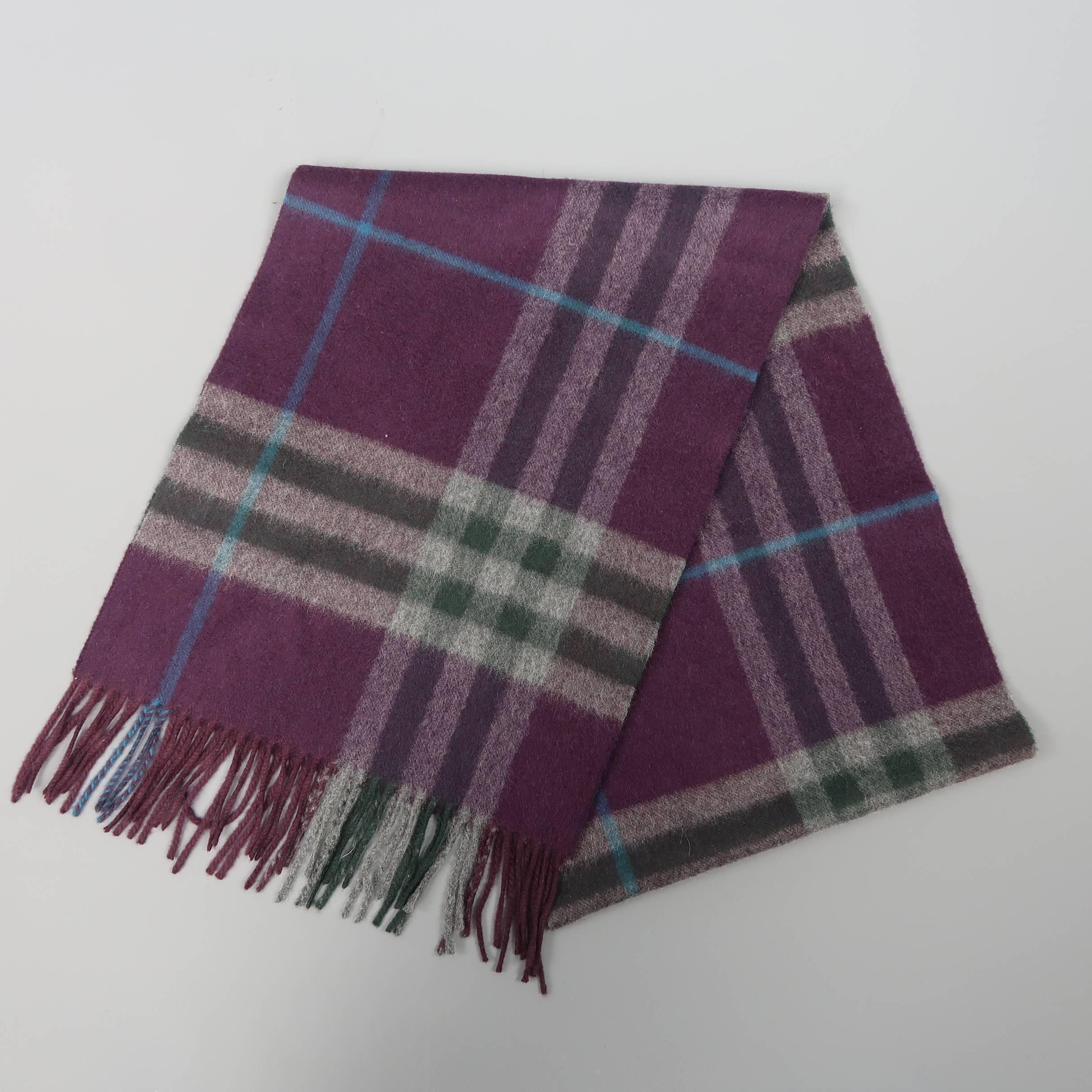 Classic BURBERRY scarf comes in eggplant purple cashmere knit with all over signature plaid print detailed with hues of gray, forest green, and aqua blue and fringe trim. Made in Scotland.
 
Excellent Pre-Owned Condition.
 
Length: 64 in.
Width: 12