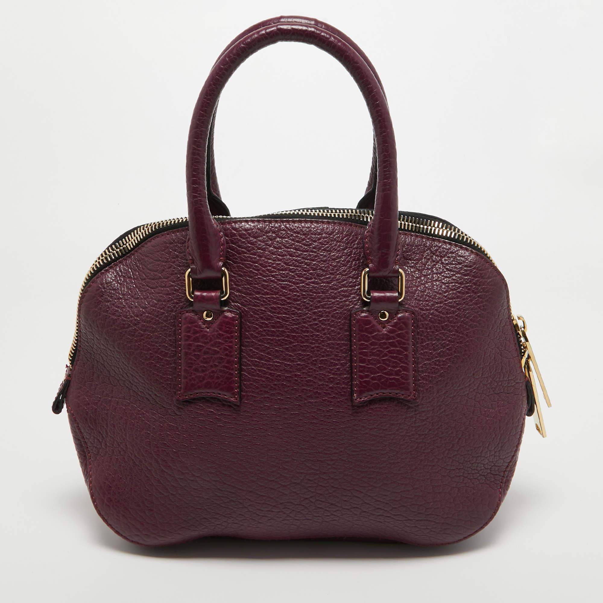 Expertly crafted and skillfully designed, this Burberry creation is a must-have in every bag collection. It is made from purple leather. Features like the two comfortable handles, detachable shoulder strap, and spacious fabric interior make it a
