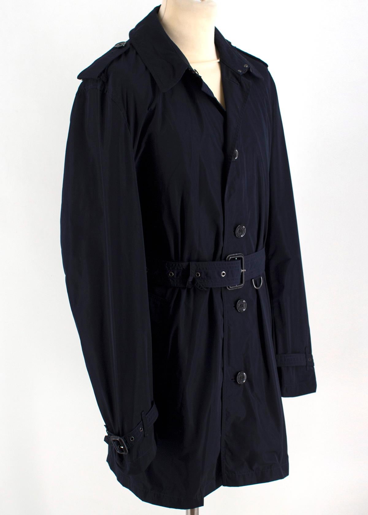 Burberry Quintessential Black Trench Coat 

- Black, single-breasted, mid-length tailored trench coat. 
- Hook-and-eye collar closure. 
- Gun flap with belted cuffs and D-ring belt
- Rear central vent and monochrome grey check lining.
- Slanted flap