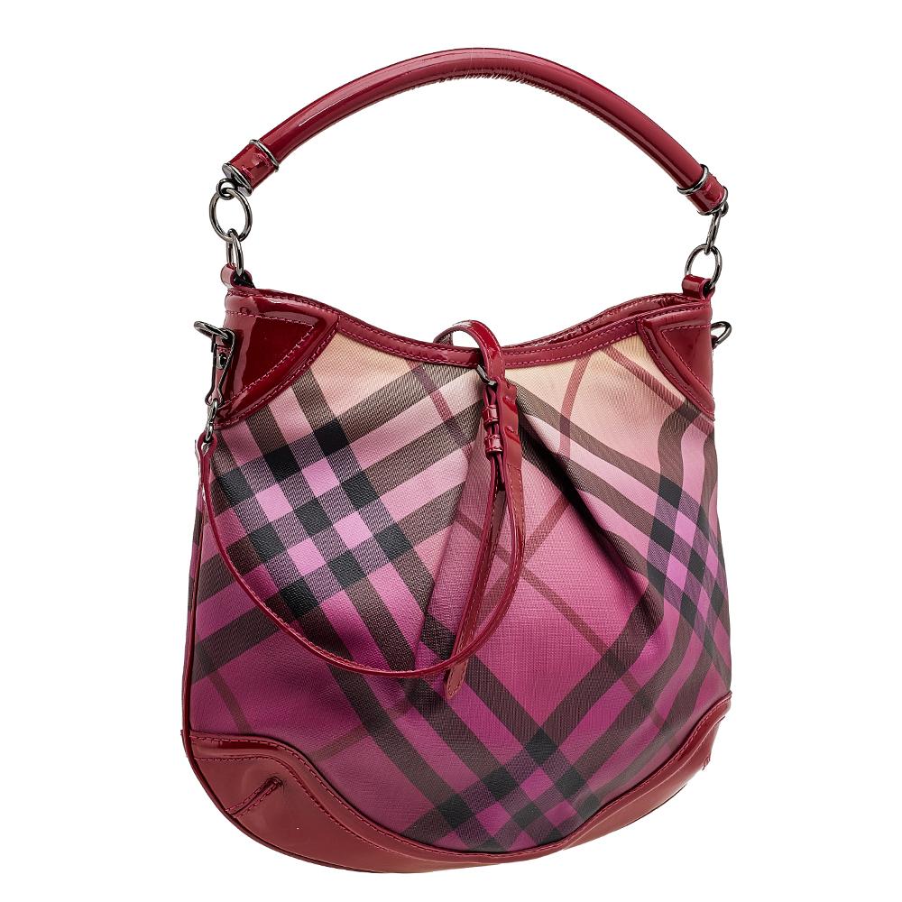Burberry handbags are every fashionista's dream come true. Crafted with the brand's signature Supernova check coated canvas and patent leather, this bag is the perfect accessory to accentuate your style quotient this season. It has a raspberry-hued