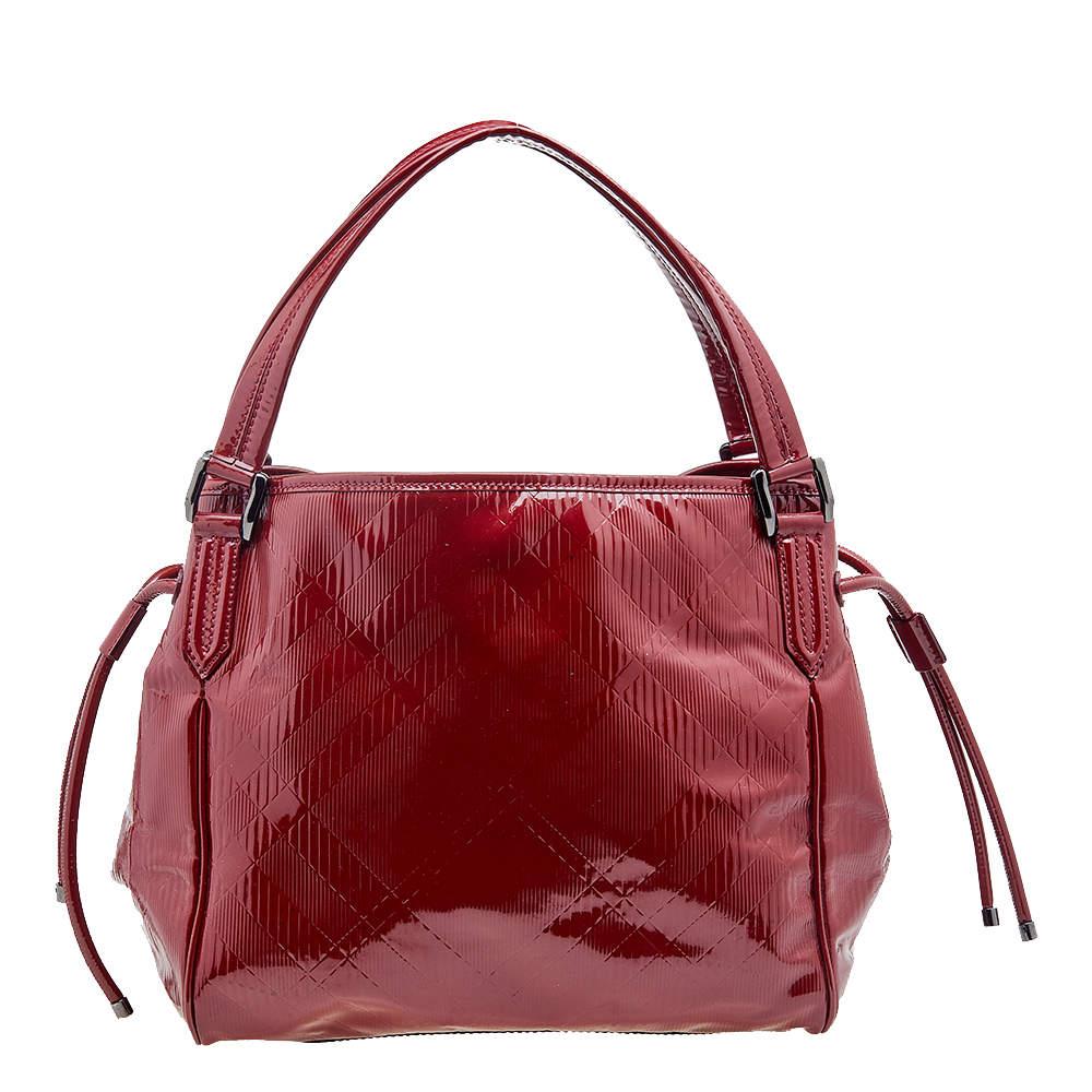 Get admiring glances when you swing this beautiful Bilmore tote by Burberry. It has been crafted from red, check-embossed patent leather. The bag has a spacious fabric interior capable of holding all your essentials and is complete with two handles