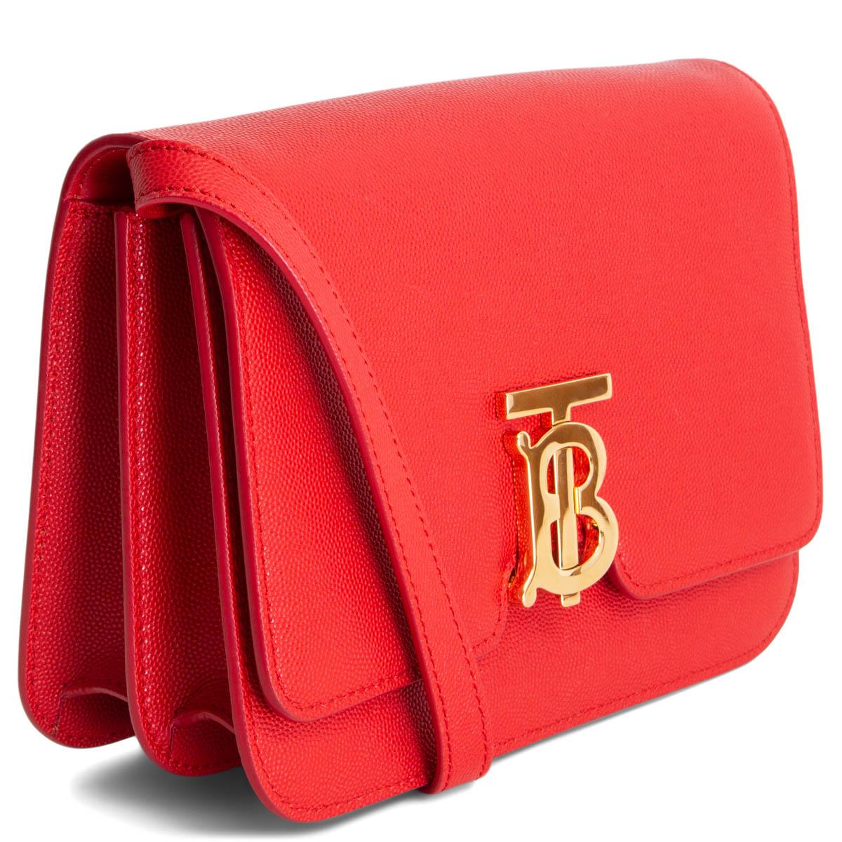 100% authentic Burberry Small TB Shoulder Bag in red grained calfskin with a gold-tone metal Thomas Burberry Monogram clasp. Opens with a flap with clasp closure and is lined in red lambskin. Has two interior compartments with one zipper pocket