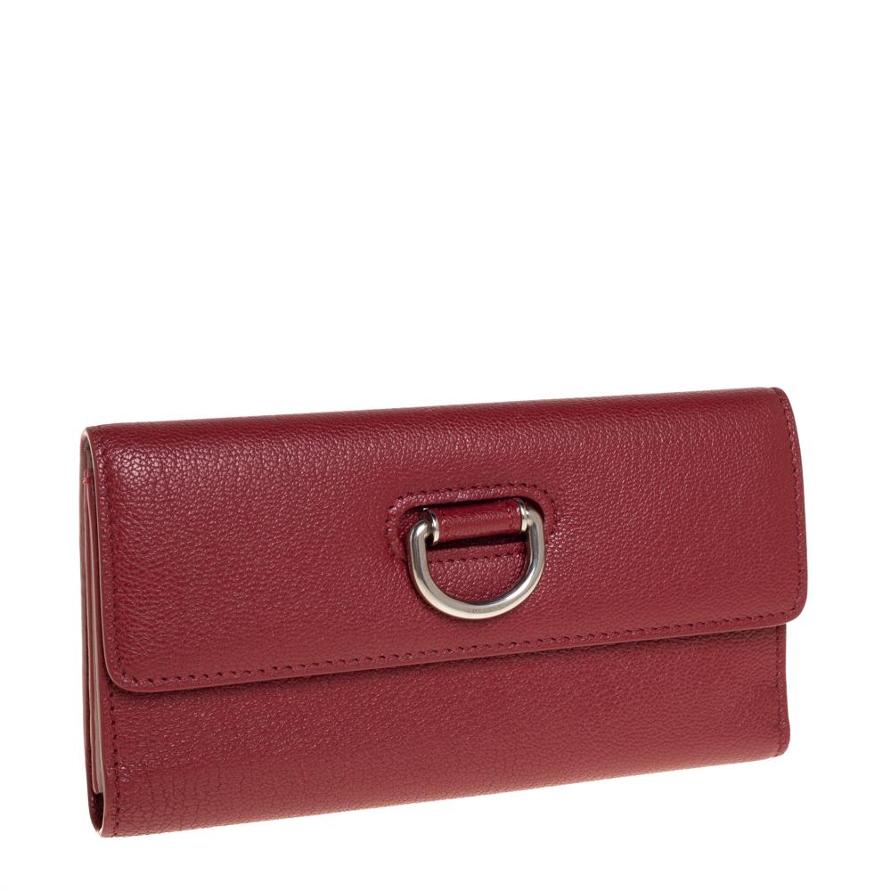 Durable and long-lasting, this wallet from Burberry is crafted from fine quality leather. Featuring a lovely red shade, it flaunts a front flap that is adorned with a silver-tone D-ring and opens to a leather and nylon interior that houses a zip