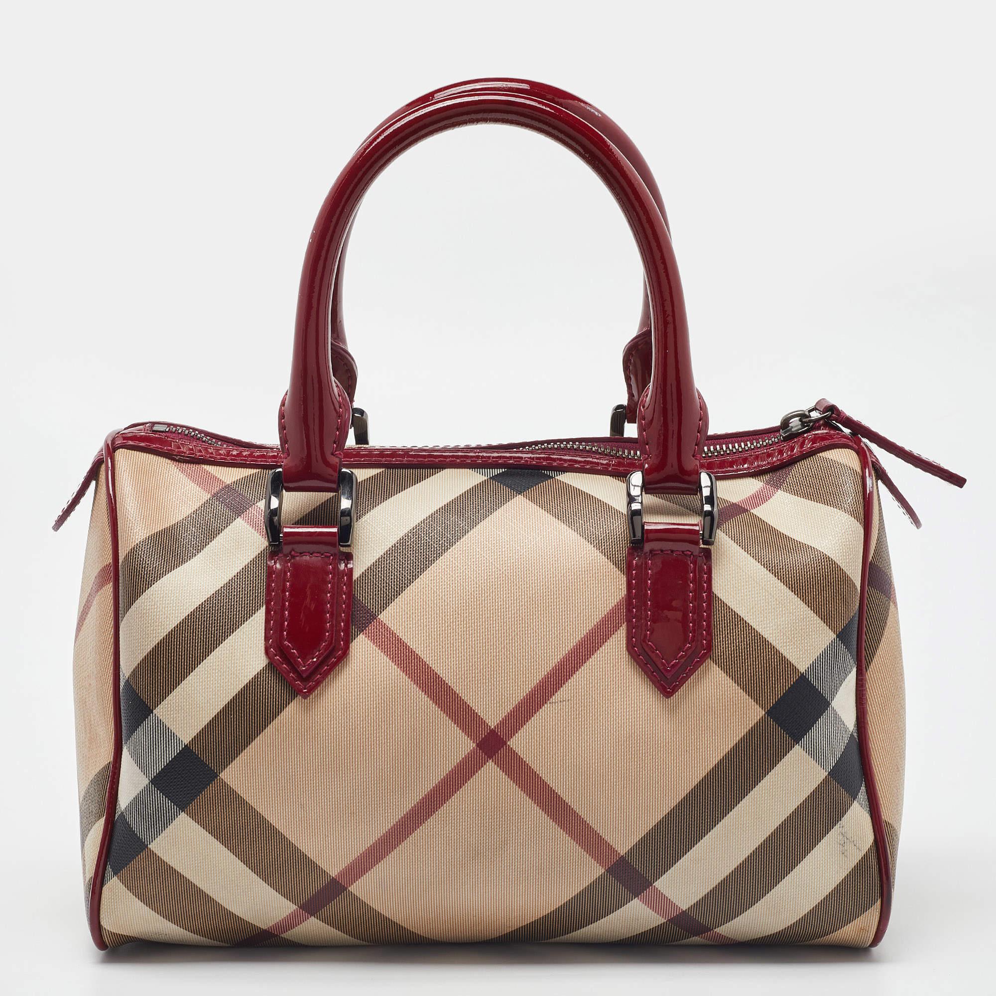 Spacious and classy, this Chester Boston bag is from Burberry. It has been crafted from their signature Nova check PVC and accented with leather trims and black-tone hardware. It is equipped with a well-sized fabric interior and two handles.


