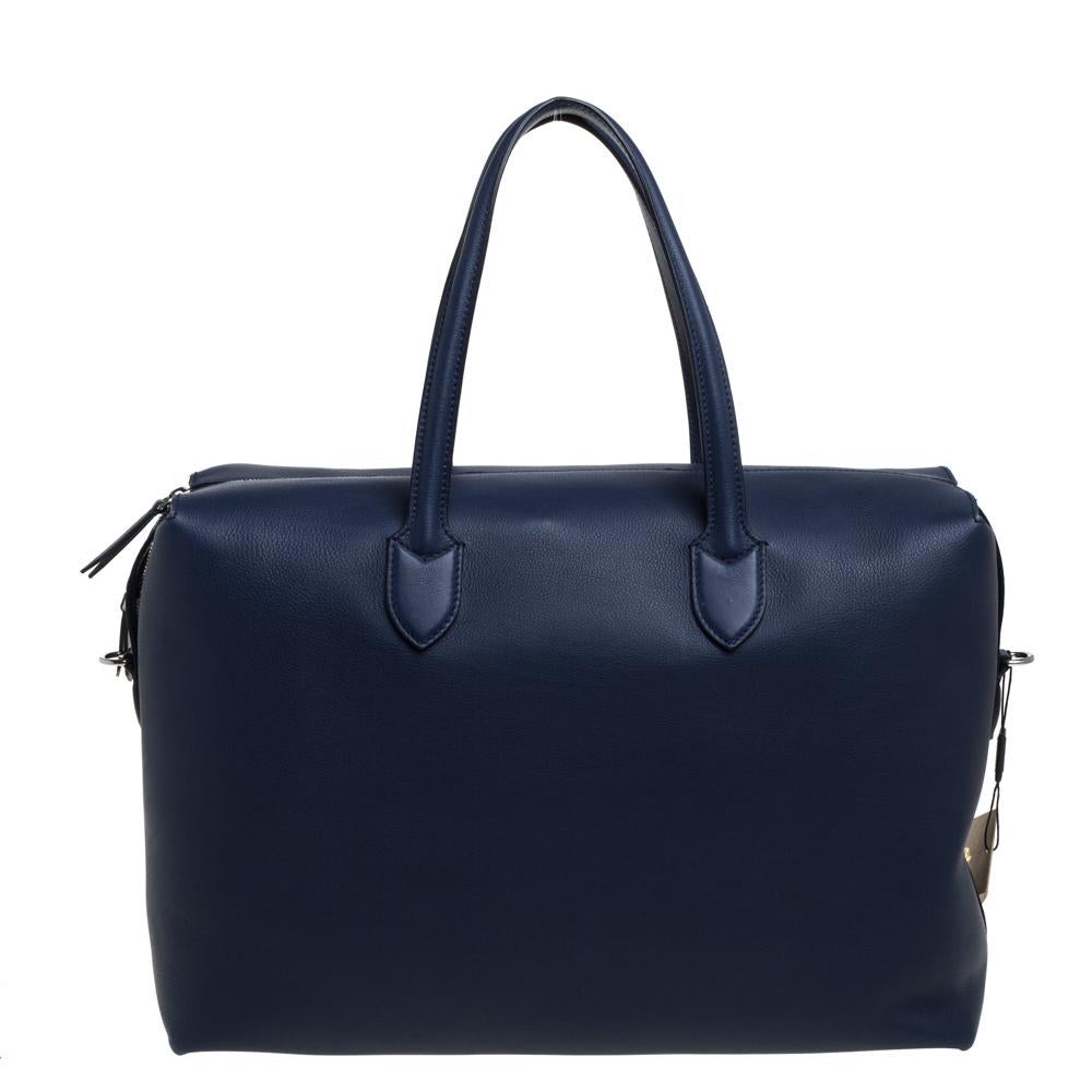 Aptly named and beautifully designed, Burberry's Lawrence Holdall bag is crafted from leather in a blue hue. The zipper closure opens to reveal a spacious interior, making the bag ideal for your travel escapades. The creation is complete with metal