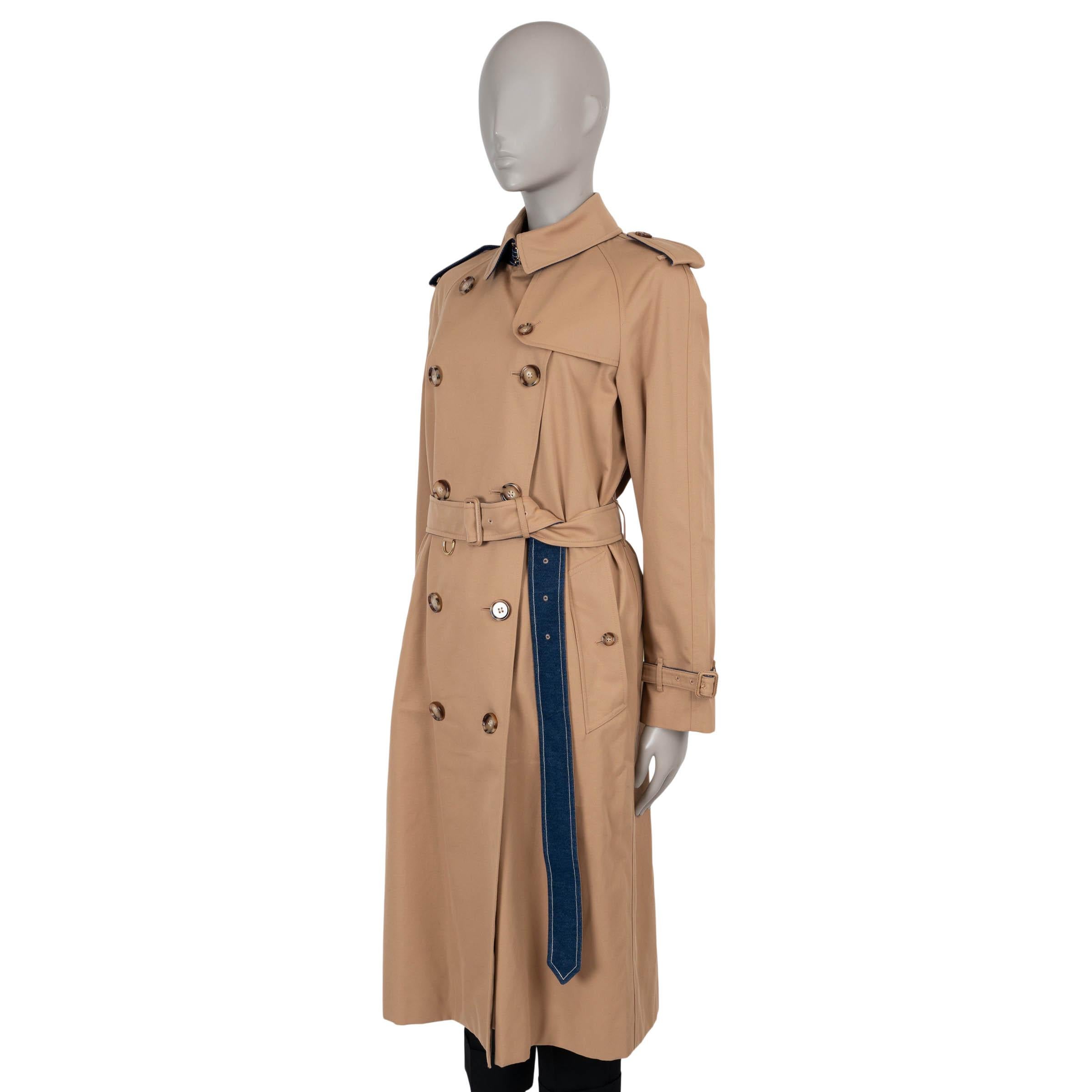 This 100% authentic Burberry Long Waterloo trench coat in sand beige gabardine cotton (100%) offers a timeless yet modern take on the classic trench. Featuring blue denim lining on the straps and under the collar, it adds a subtle contrast to its
