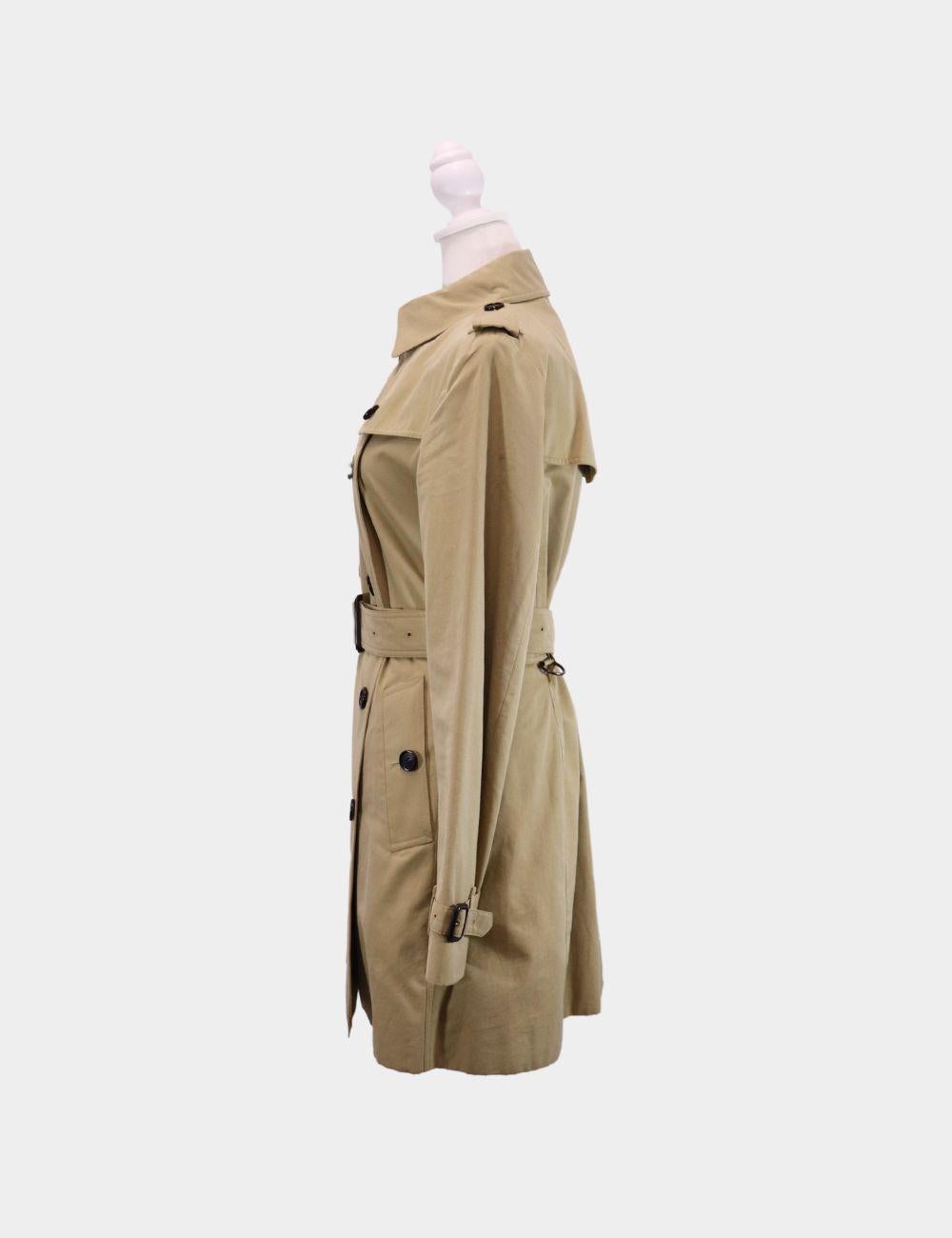 Burberry Short Kensington Heritage Trench Coat, Features Double-breasted button closure, Waist Belt, Side button welt pockets and long sleeves.

Material: 100% cotton
Size: UK 12 / L
Bust 96cm
Waist 79cm
Hips 104cm
Condition: Good