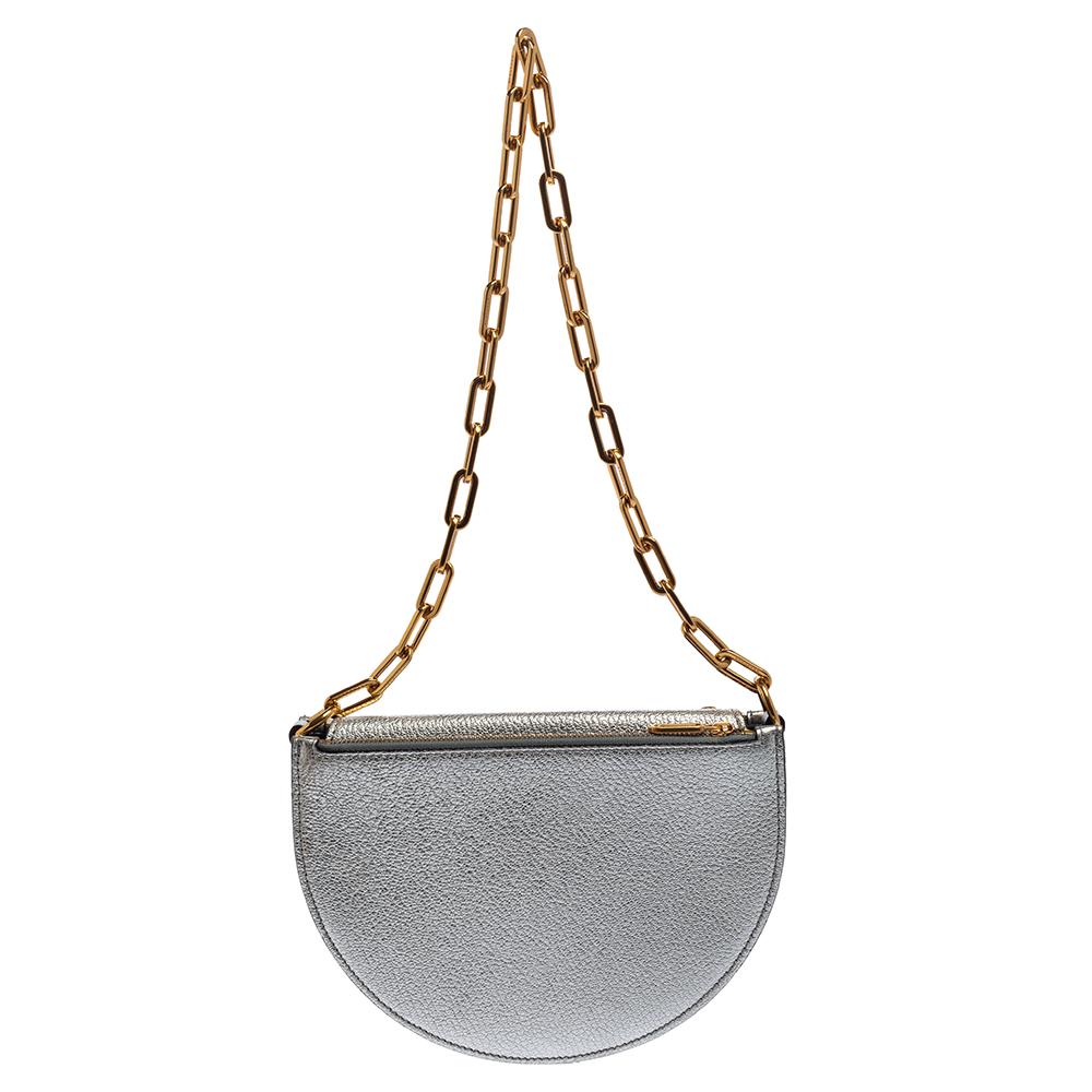 A stellar creation by Burberry, this shoulder bag is brimming with luxury and beauty. Crafted from silver foil leather, it features a chic half-moon shape that suspends from an opulent chain link. Carry this artistic bag and win all the admiring