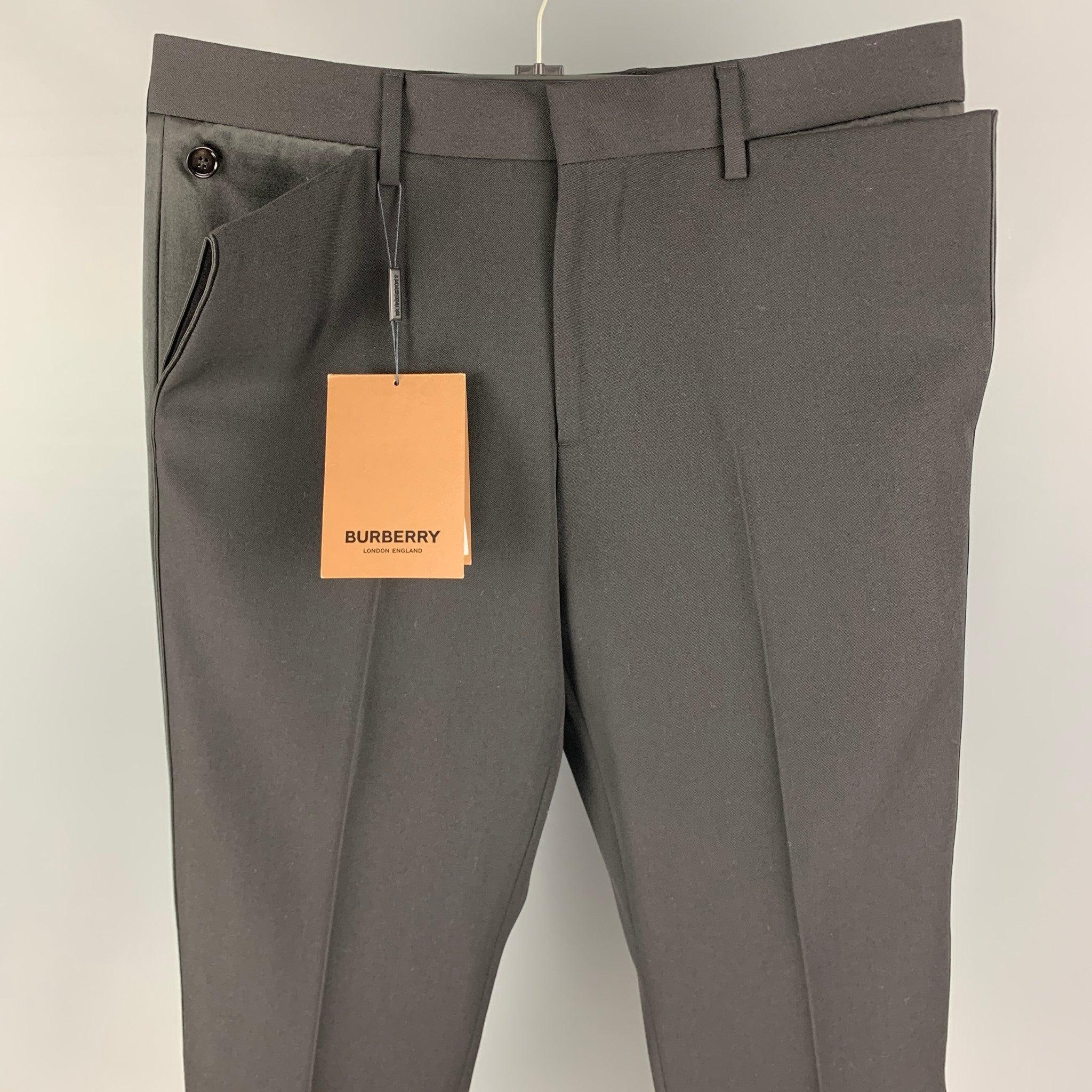BURBERRY dress pants comes in a black wool featuring a flat front, buttoned details, front tab, and a zip fly closure. Made in Italy.
New with tags. 

Marked:   48 

Measurements: 
  Waist: 32 inches Rise: 10 inches Inseam: 32 inches Leg Opening: 16