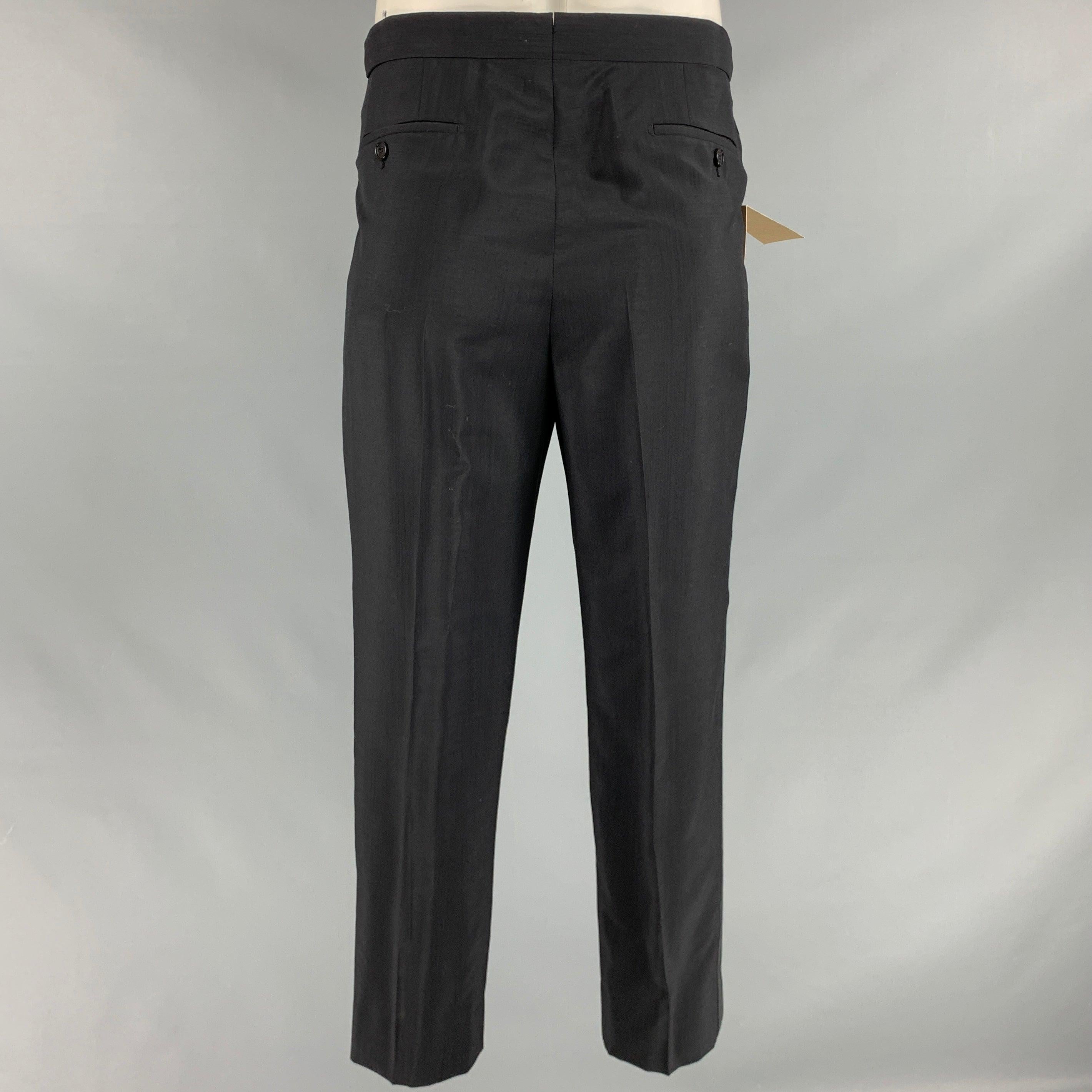 BURBERRY tuxedo pants
in a black wool mohair blend fabric featuring tuxedo stripes, side tabs, and zip fly closure. Made in Italy. Note: this item has been altered, please check measurements.Very Good Pre-Owned Condition with Tags. Minor hole on