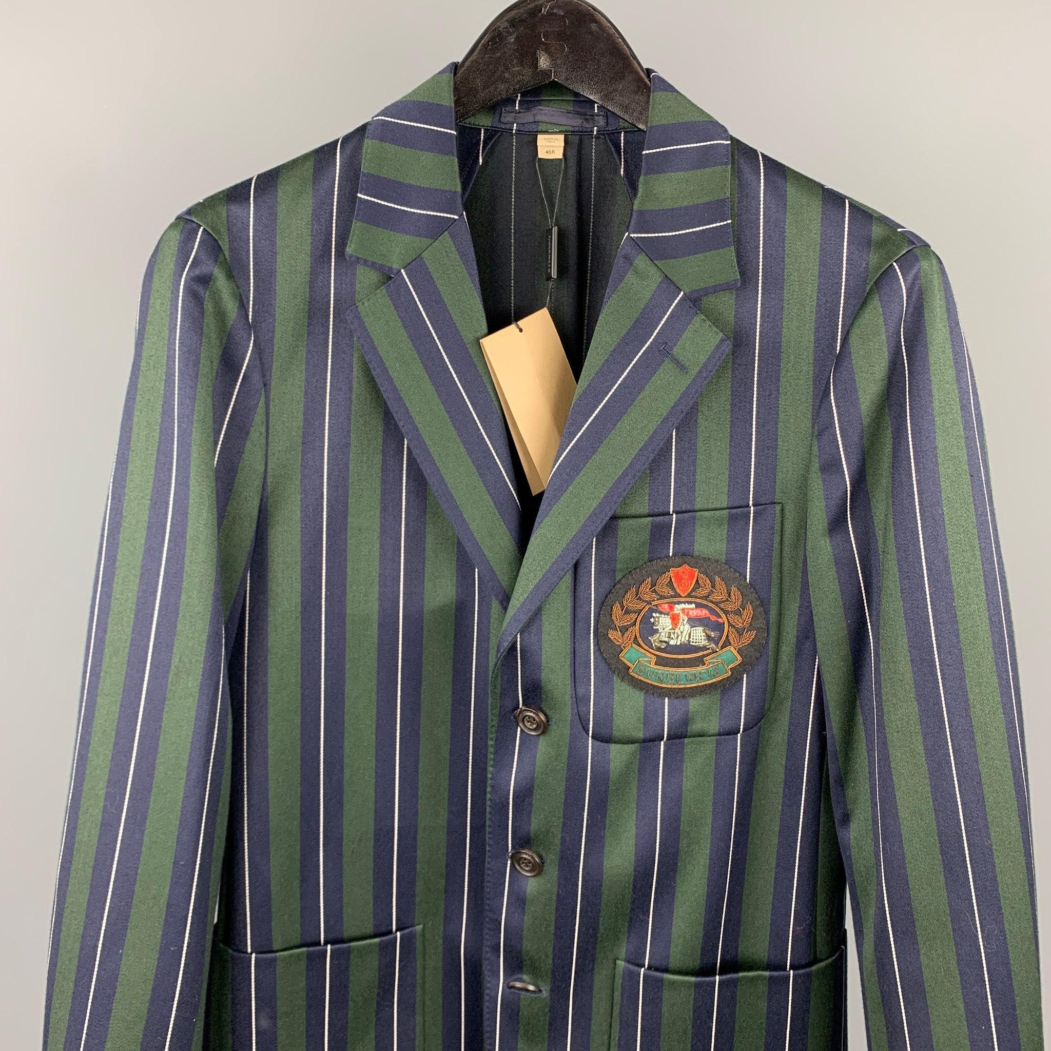 BURBERRY
suit comes in a green & navy vertical stripe wool / cotton with a half liner and front embroidered patch featuring a single breasted, three button sport coat with a notch lapel and matching flat front trousers. Made in Italy. New With Tags.